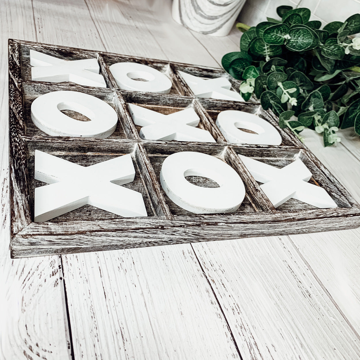 Rustic Tic Tac Toe game featuring a handmade wooden base with removable white and blackened game pieces, perfect for home decor and family fun.