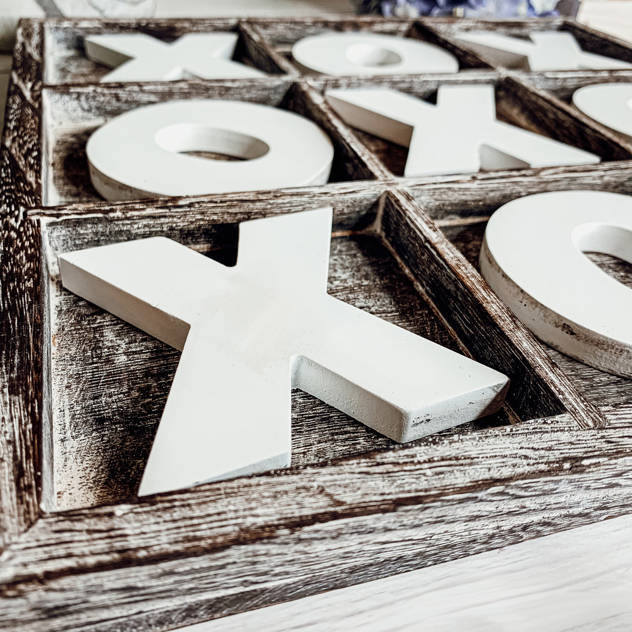 Rustic Tic Tac Toe game featuring a handmade wooden base with removable white and blackened game pieces, perfect for home decor and family fun.