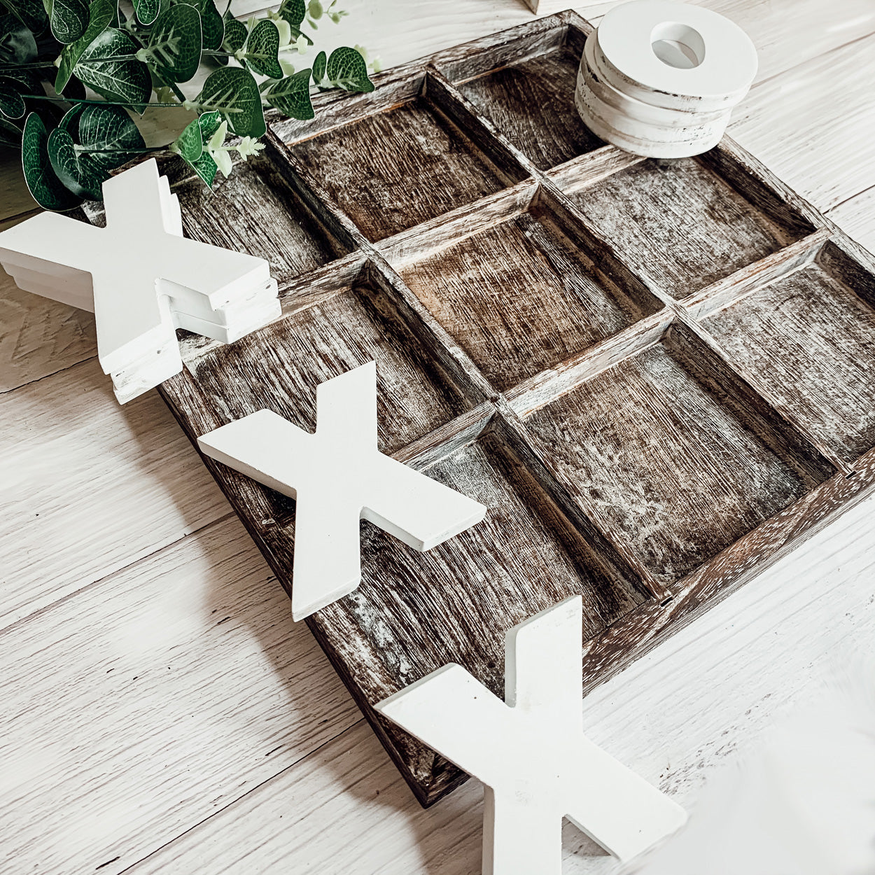 Rustic Tic Tac Toe game featuring a handmade wooden base with removable white and blackened game pieces, perfect for home decor and family fun.