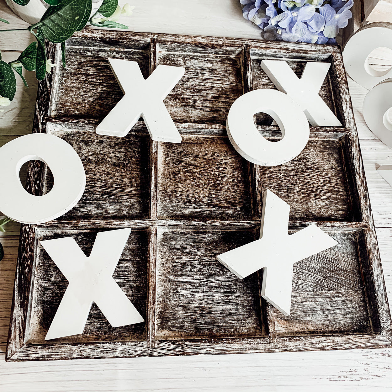 Rustic Tic Tac Toe game featuring a handmade wooden base with removable white and blackened game pieces, perfect for home decor and family fun.