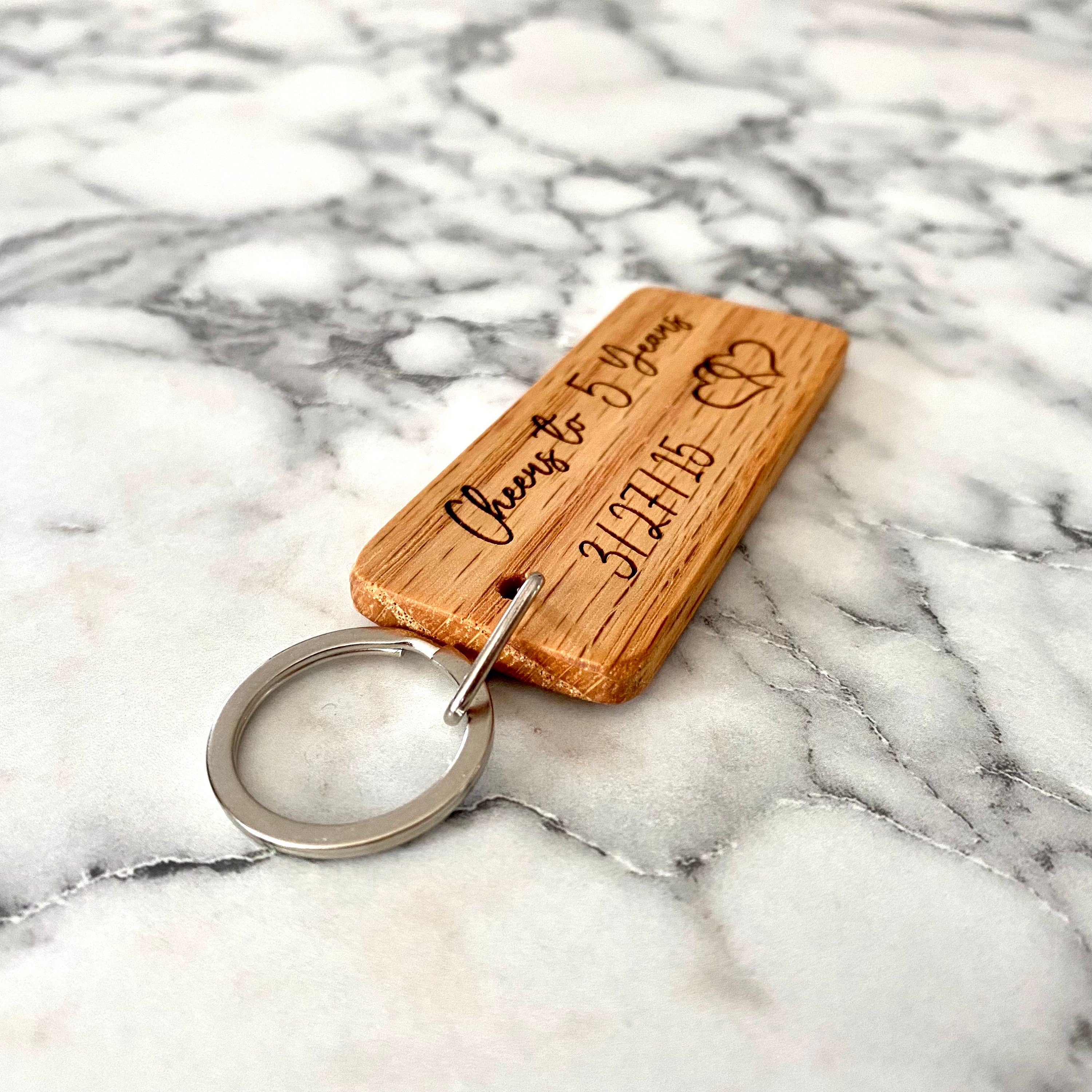 Engraved wood keychain featuring hearts and a custom date, perfect for 5-year anniversary gifts.