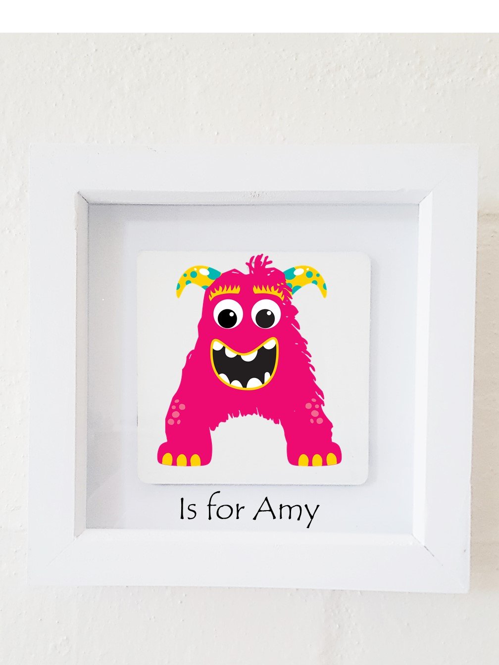 A colorful framed plaque featuring a monster design, personalized with a child's initial and name, perfect for children's bedroom decor.