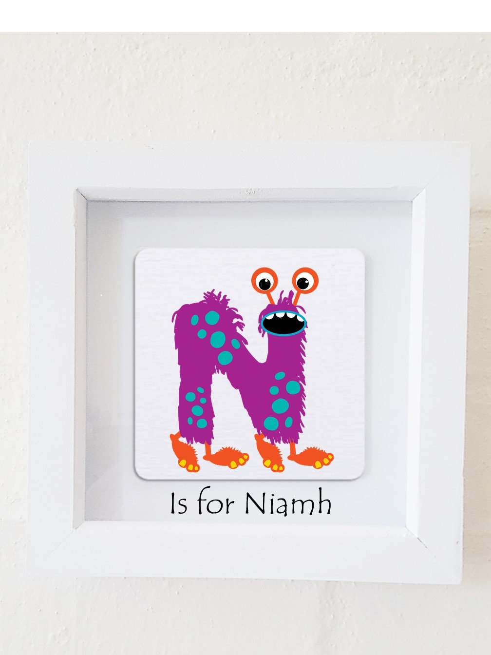 A colorful framed plaque featuring a monster design, personalized with a child's initial and name, perfect for children's bedroom decor.