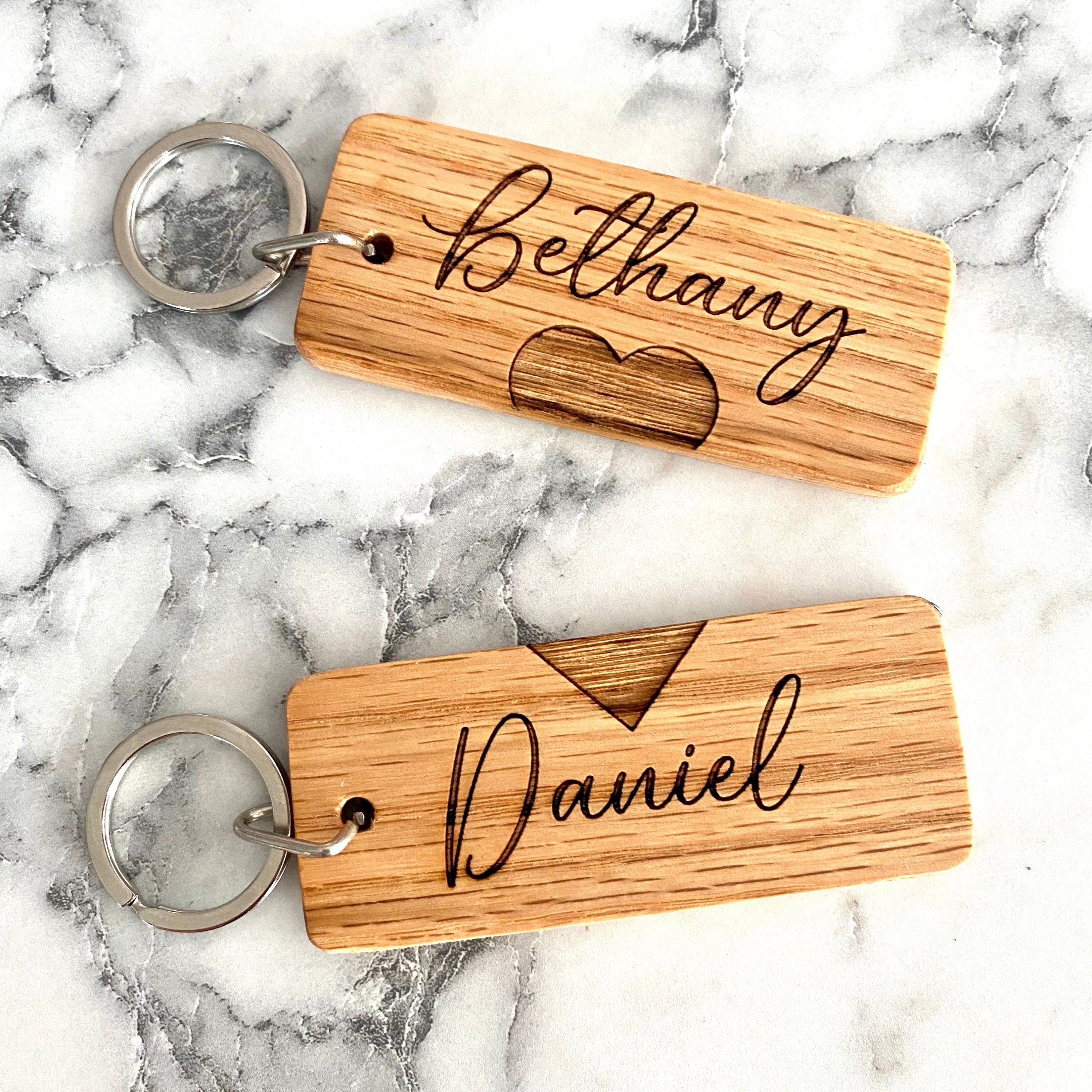 Couples Engraved Wood Keychain set featuring personalized names and a joined heart design, crafted from solid hardwood oak.