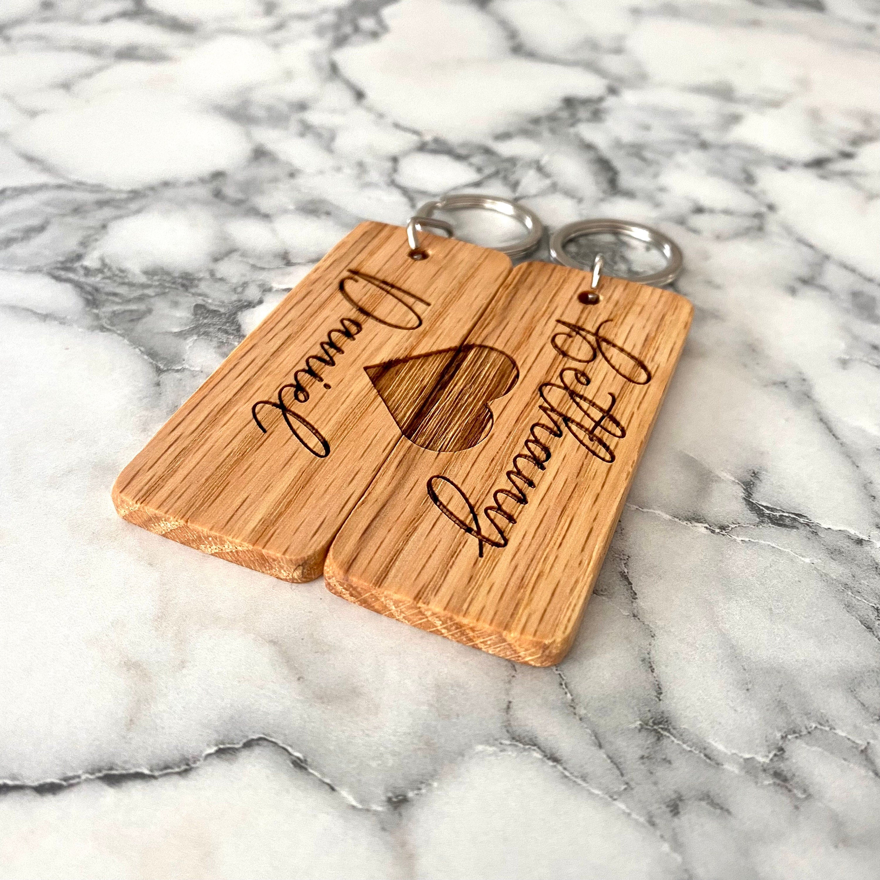 Couples Engraved Wood Keychain set featuring personalized names and a joined heart design, crafted from solid hardwood oak.