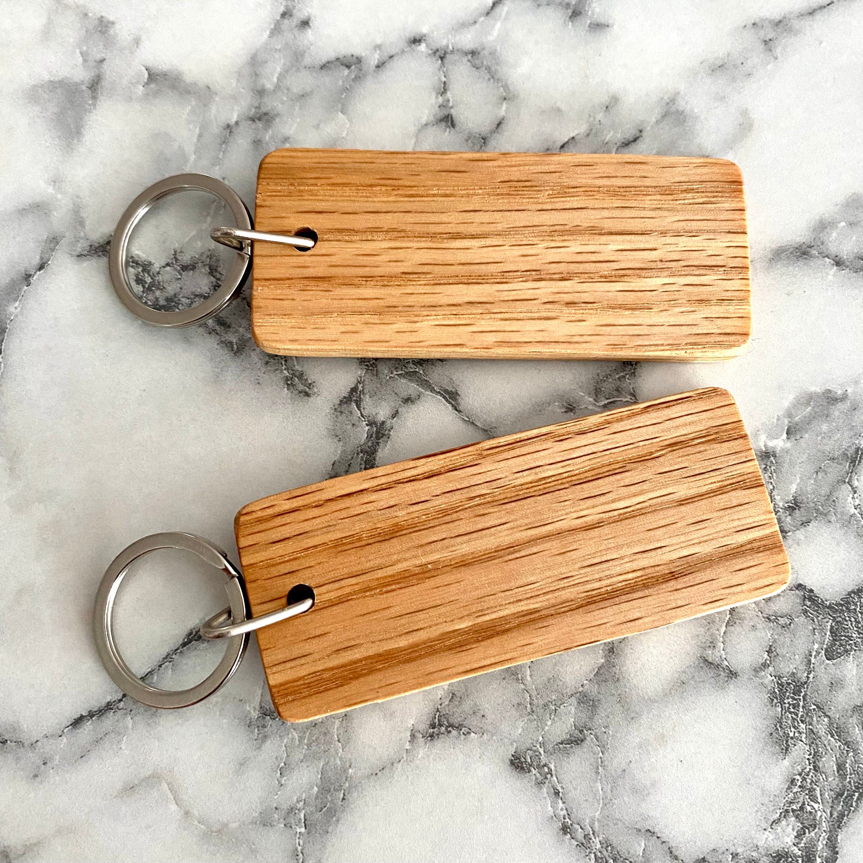 Couples Engraved Wood Keychain set featuring personalized names and a joined heart design, crafted from solid hardwood oak.