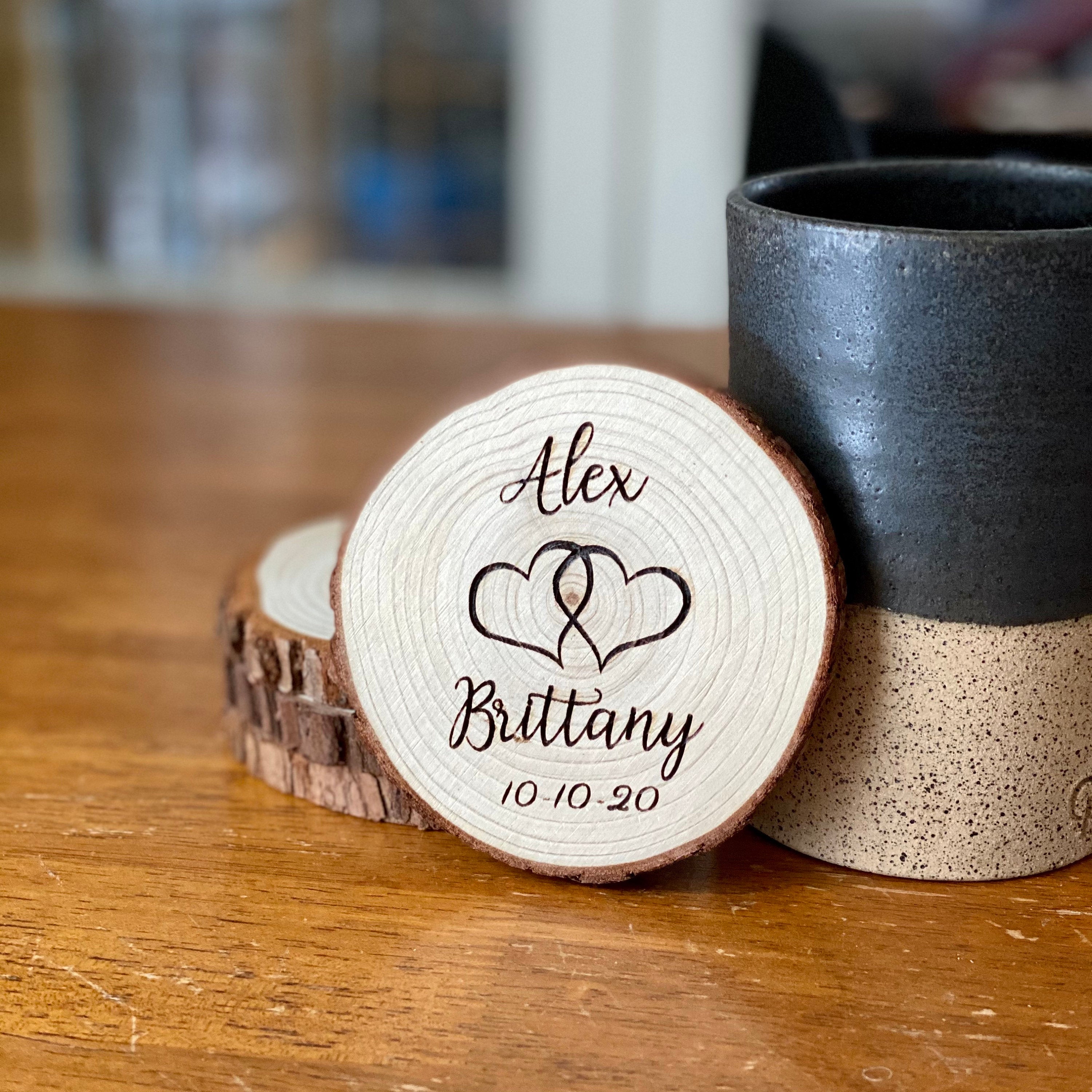 Set of personalized wood coasters with custom names and date engraved on rustic Californian Pine wood slices.