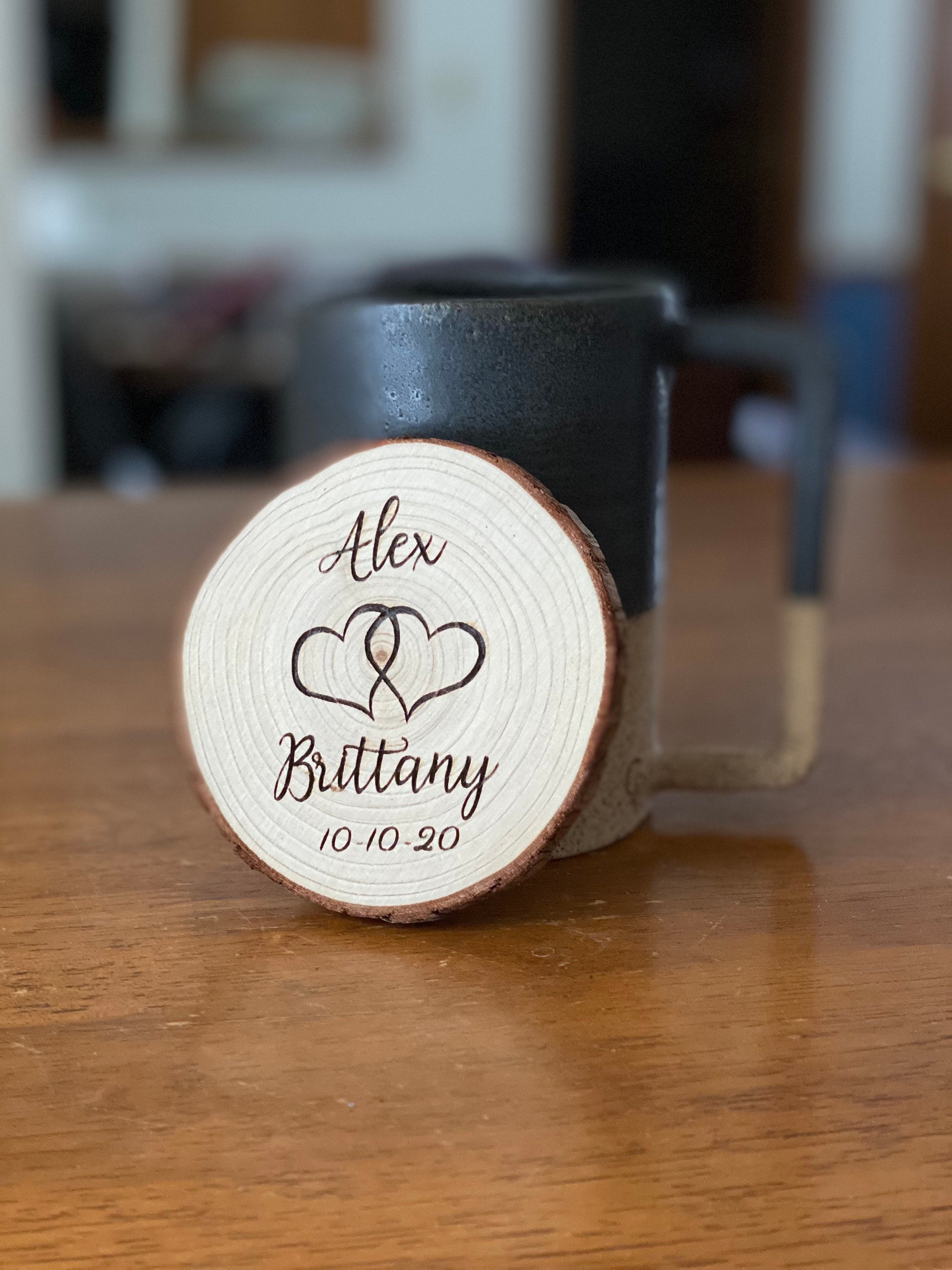 Set of personalized wood coasters with custom names and date engraved on rustic Californian Pine wood slices.