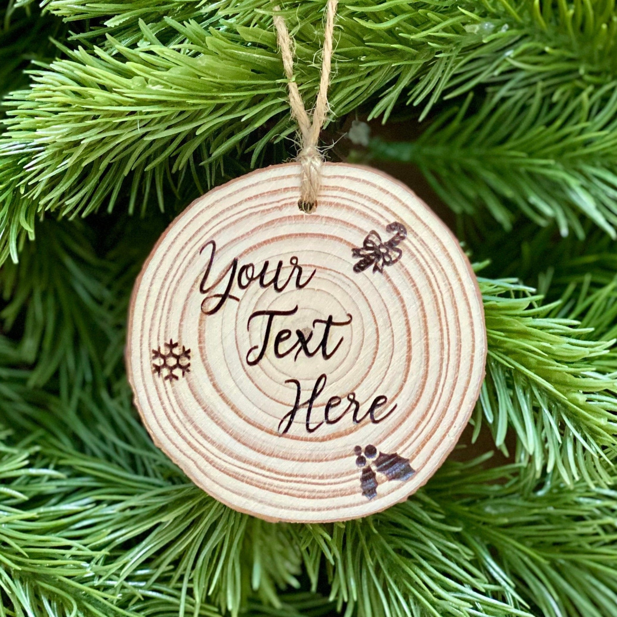 Custom engraved wood slice Christmas ornament with snowflake and holly designs, showcasing rustic charm.