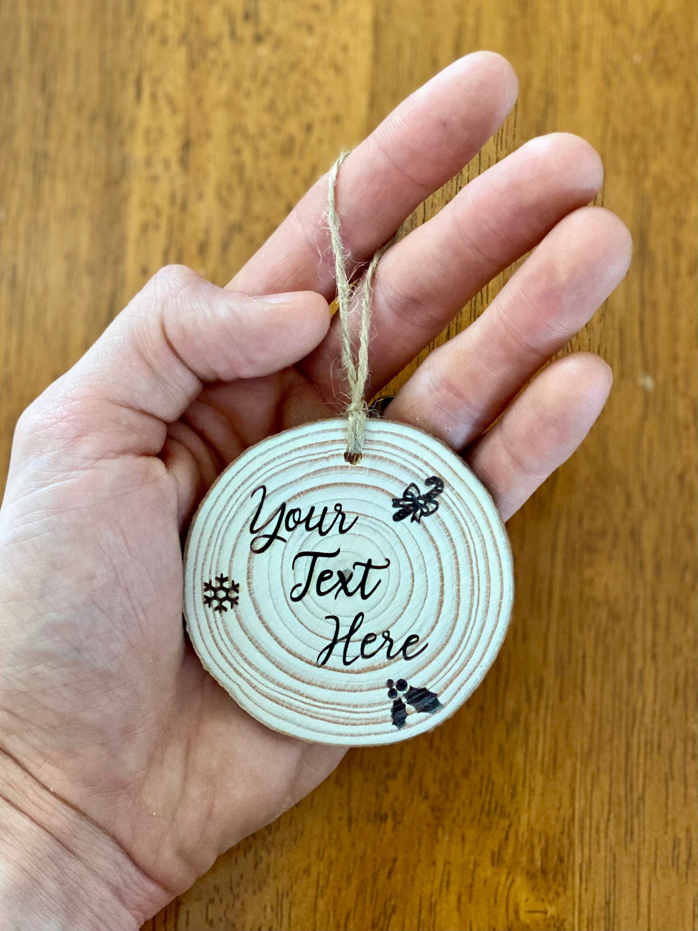 Custom engraved wood slice Christmas ornament with snowflake and holly designs, showcasing rustic charm.