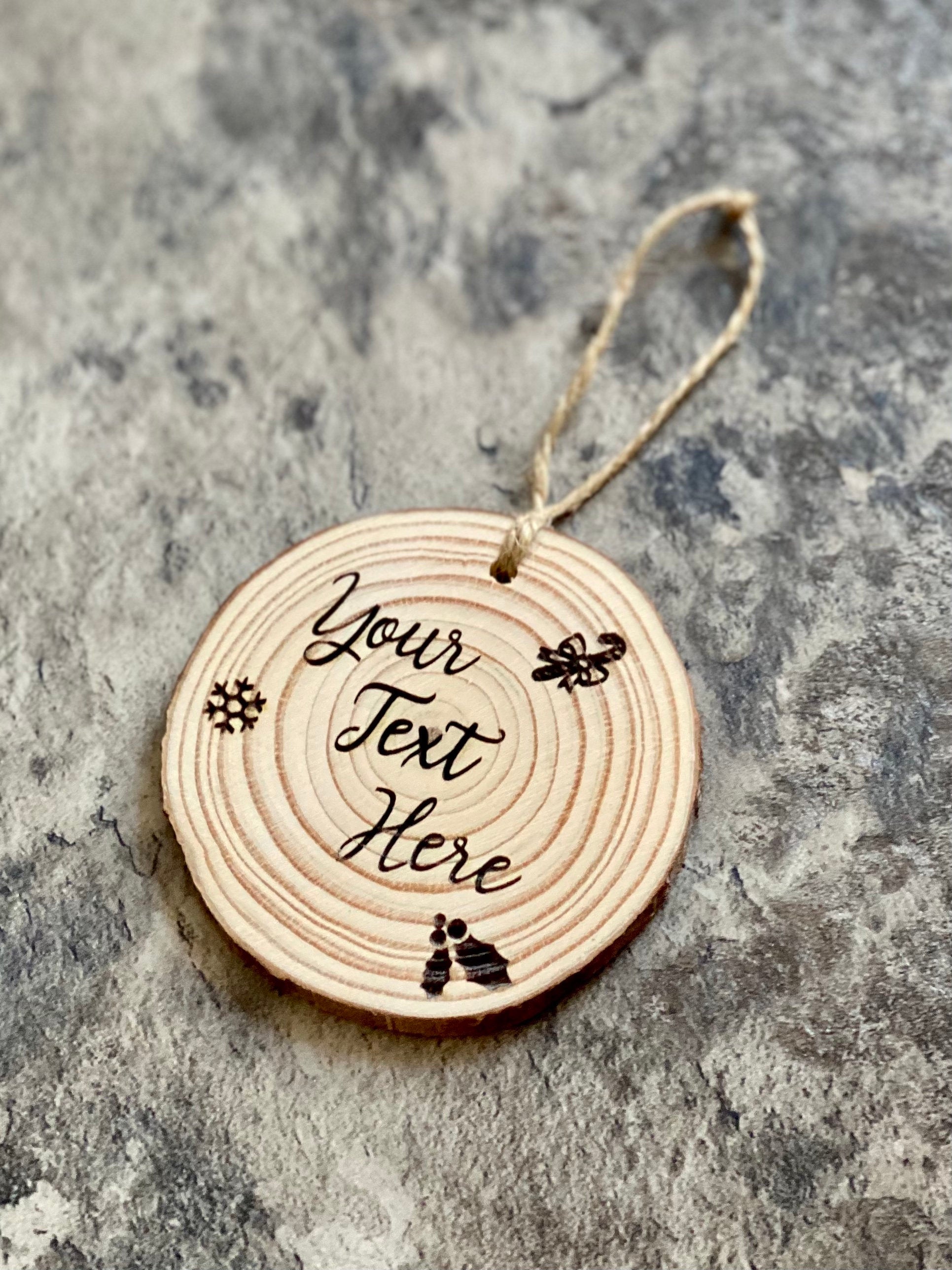 Custom engraved wood slice Christmas ornament with snowflake and holly designs, showcasing rustic charm.