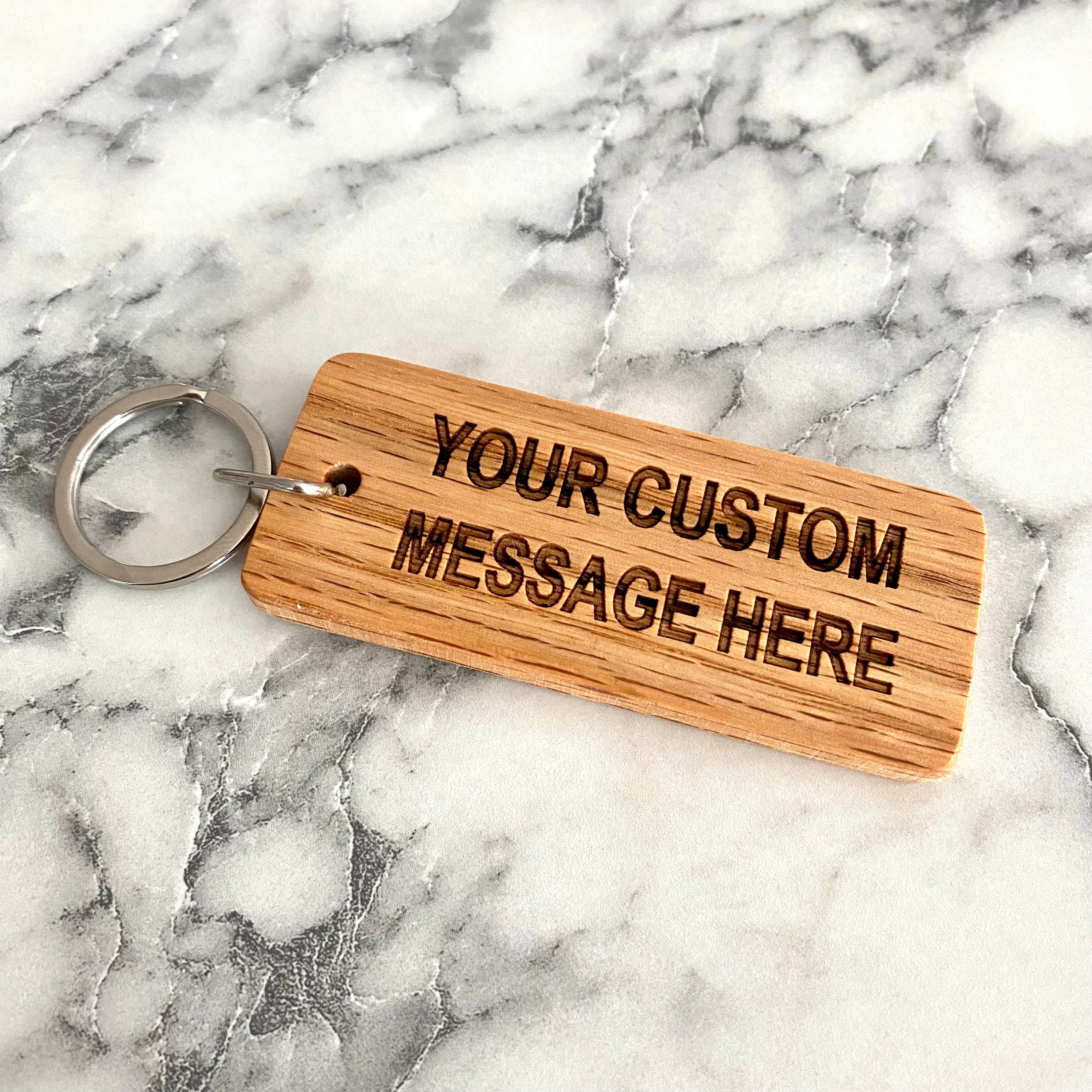 Custom engraved wood keychain made from solid oak, featuring personalized text and a smooth finish.