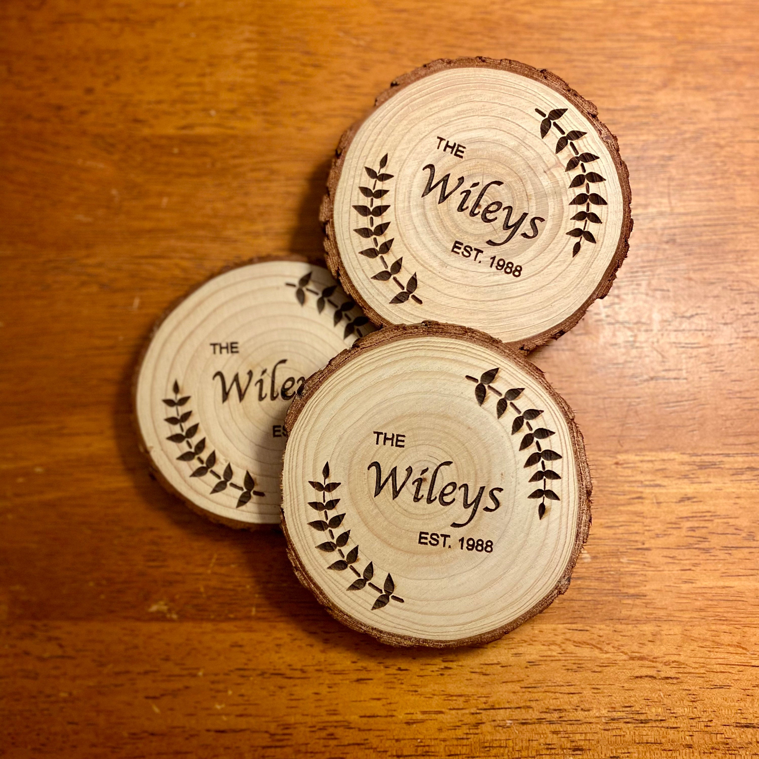 Custom wood coasters featuring engraved family name and year, made from Californian Pine, showcasing rustic charm.