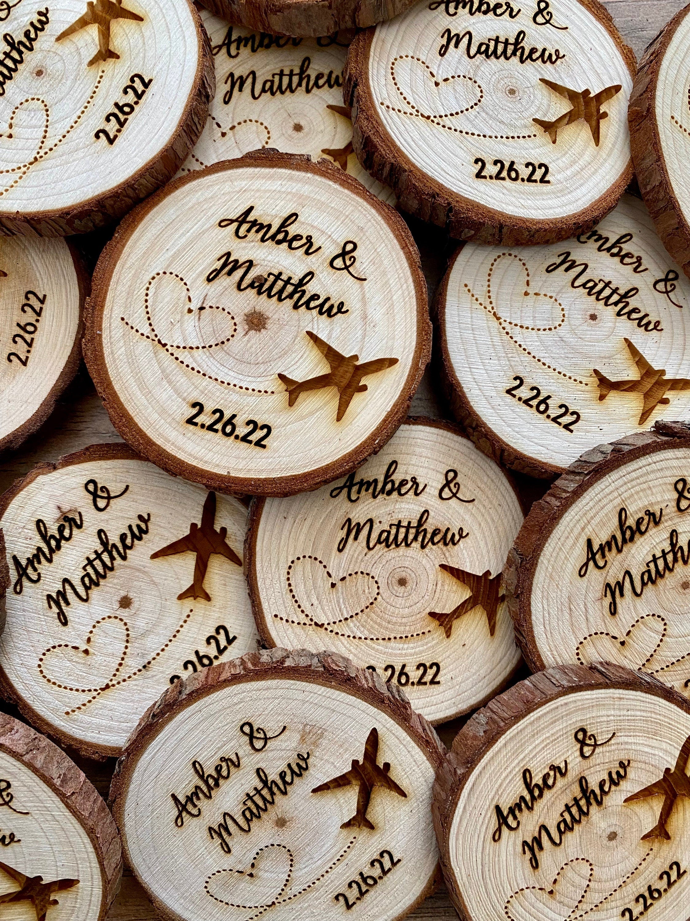 Personalized wood slice wedding favor featuring airplane design, engraved with couple's names and wedding date, with a magnet on the back.