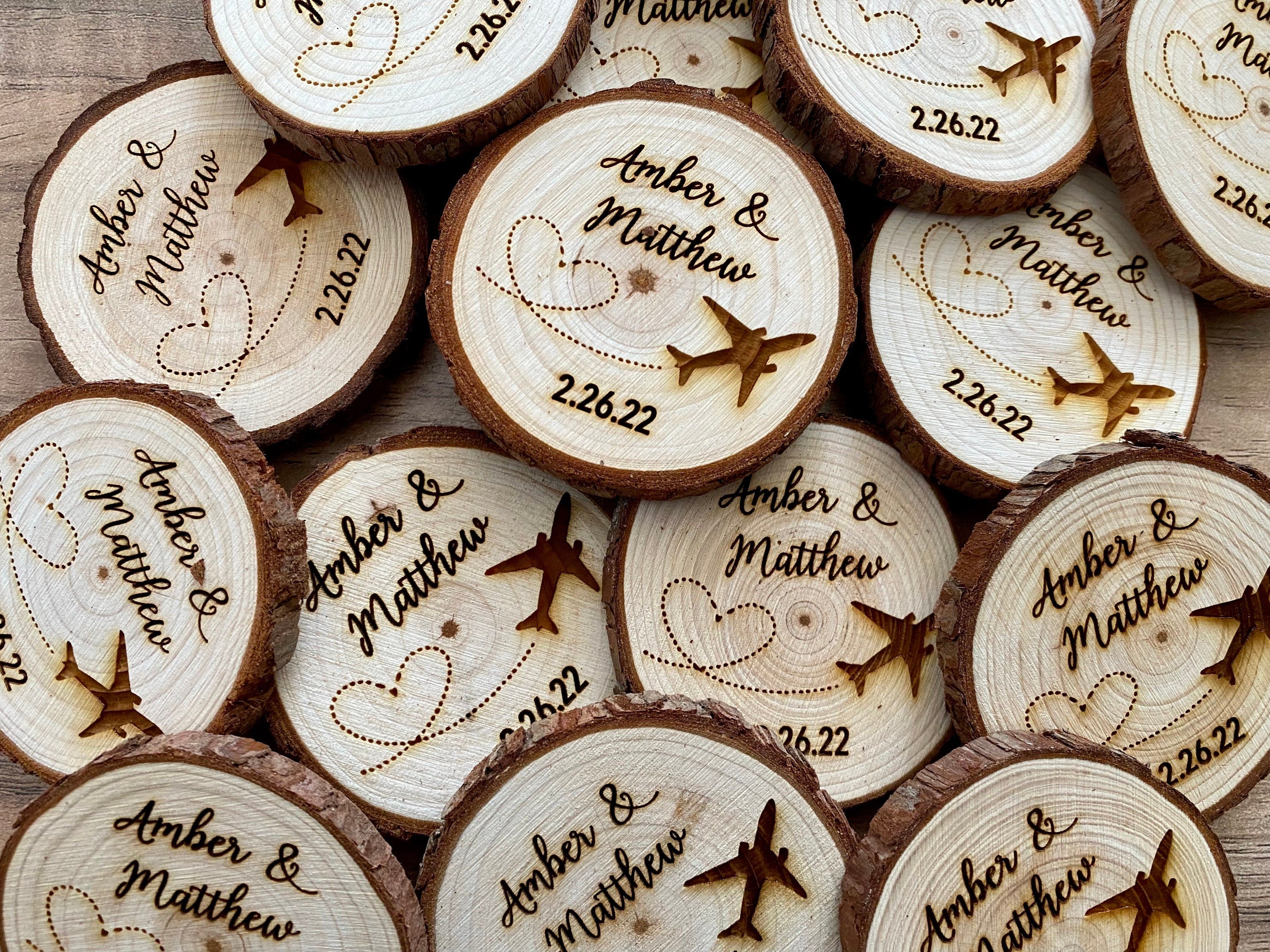 Personalized wood slice wedding favor featuring airplane design, engraved with couple's names and wedding date, with a magnet on the back.