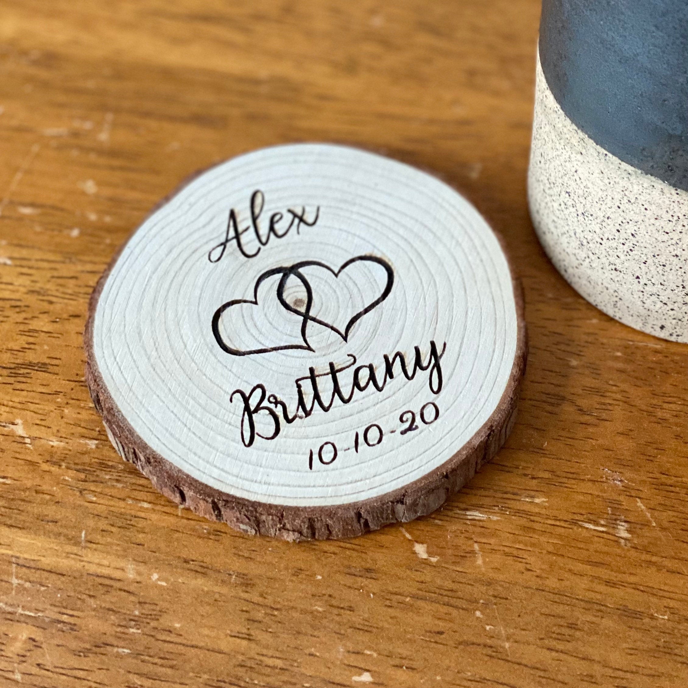 Personalized wood slice wedding favors engraved with names and date, showcasing rustic charm.