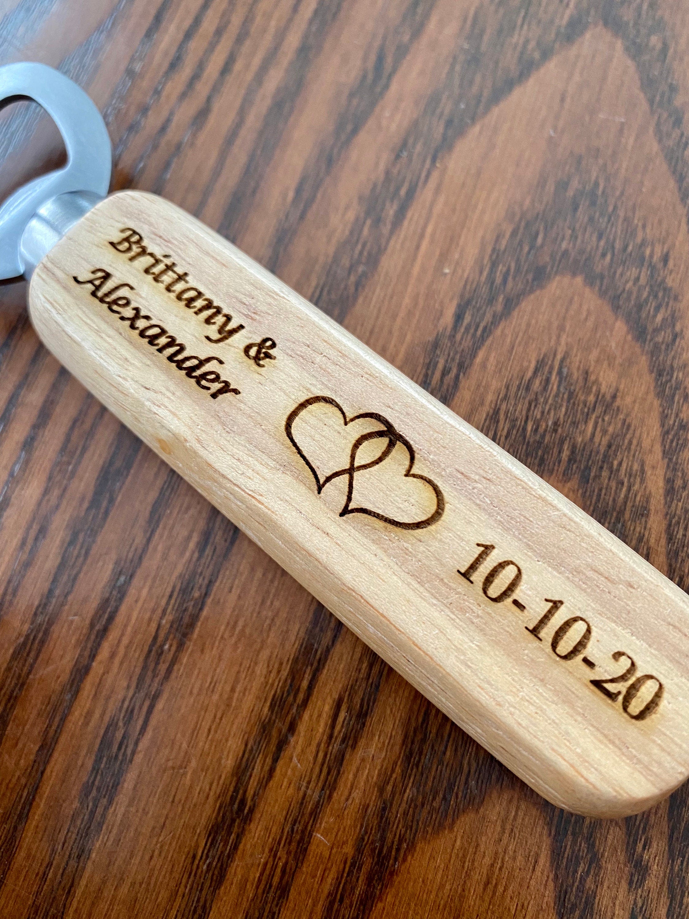 Personalized engraved wood bottle opener with heart design, perfect for weddings.