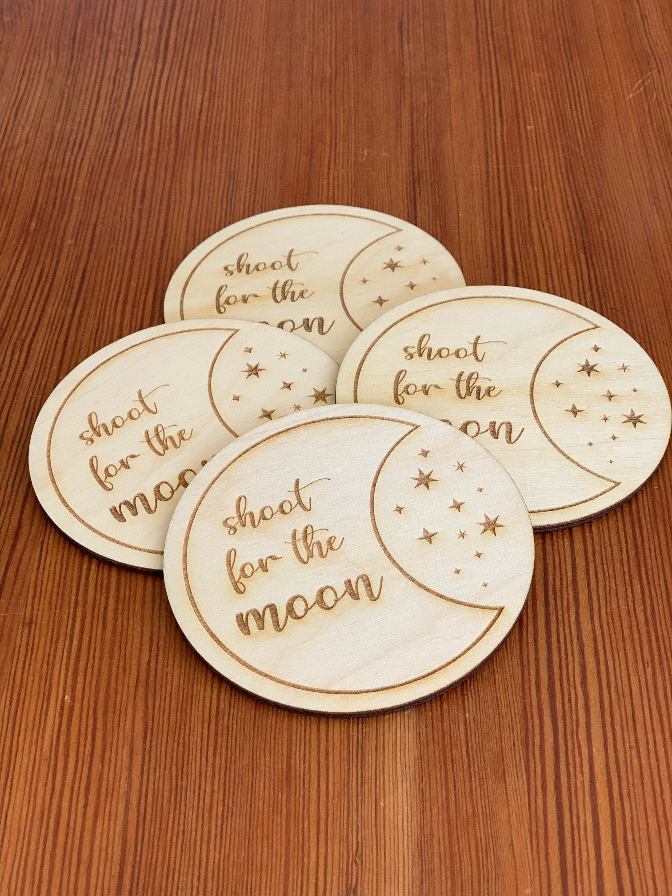 Engraved wood coasters featuring a moon and stars design, made from Baltic Birch, showcasing a rustic yet refined look.