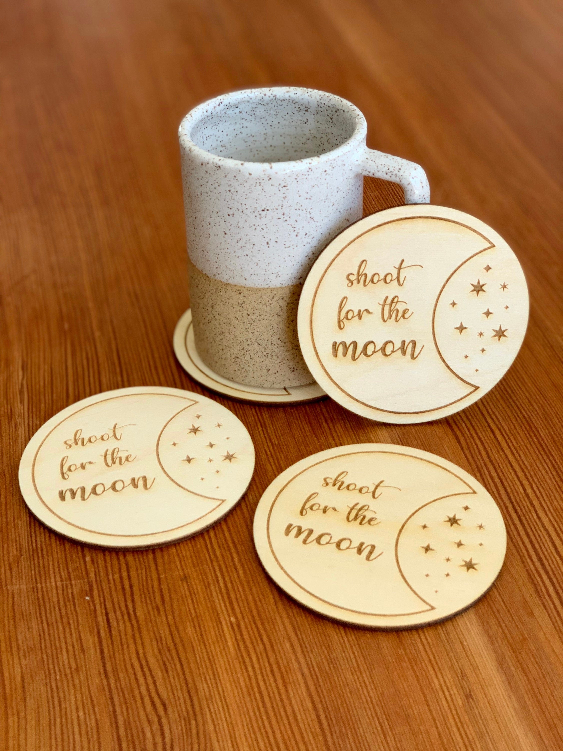 Engraved wood coasters featuring a moon and stars design, made from Baltic Birch, showcasing a rustic yet refined look.