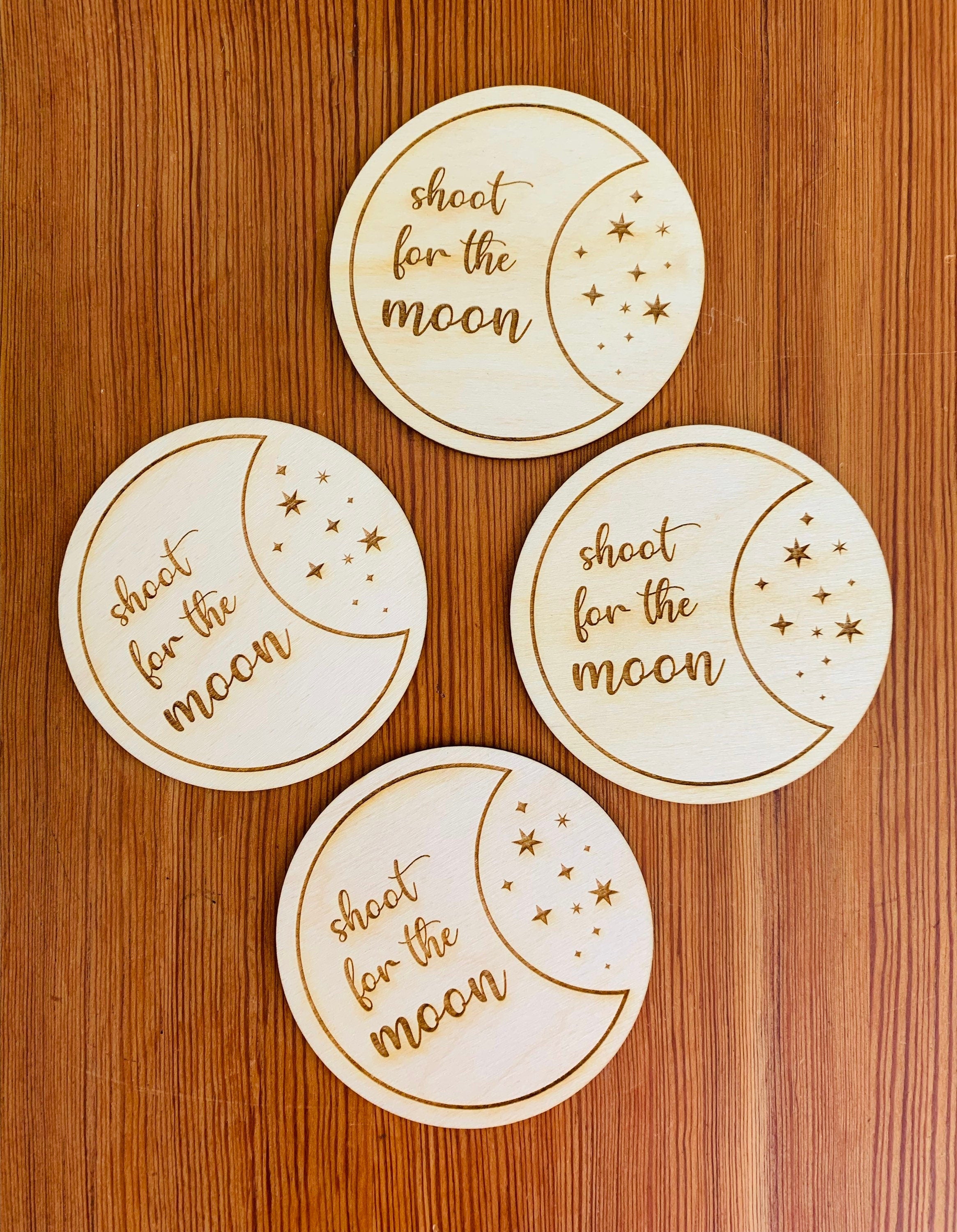 Engraved wood coasters featuring a moon and stars design, made from Baltic Birch, showcasing a rustic yet refined look.