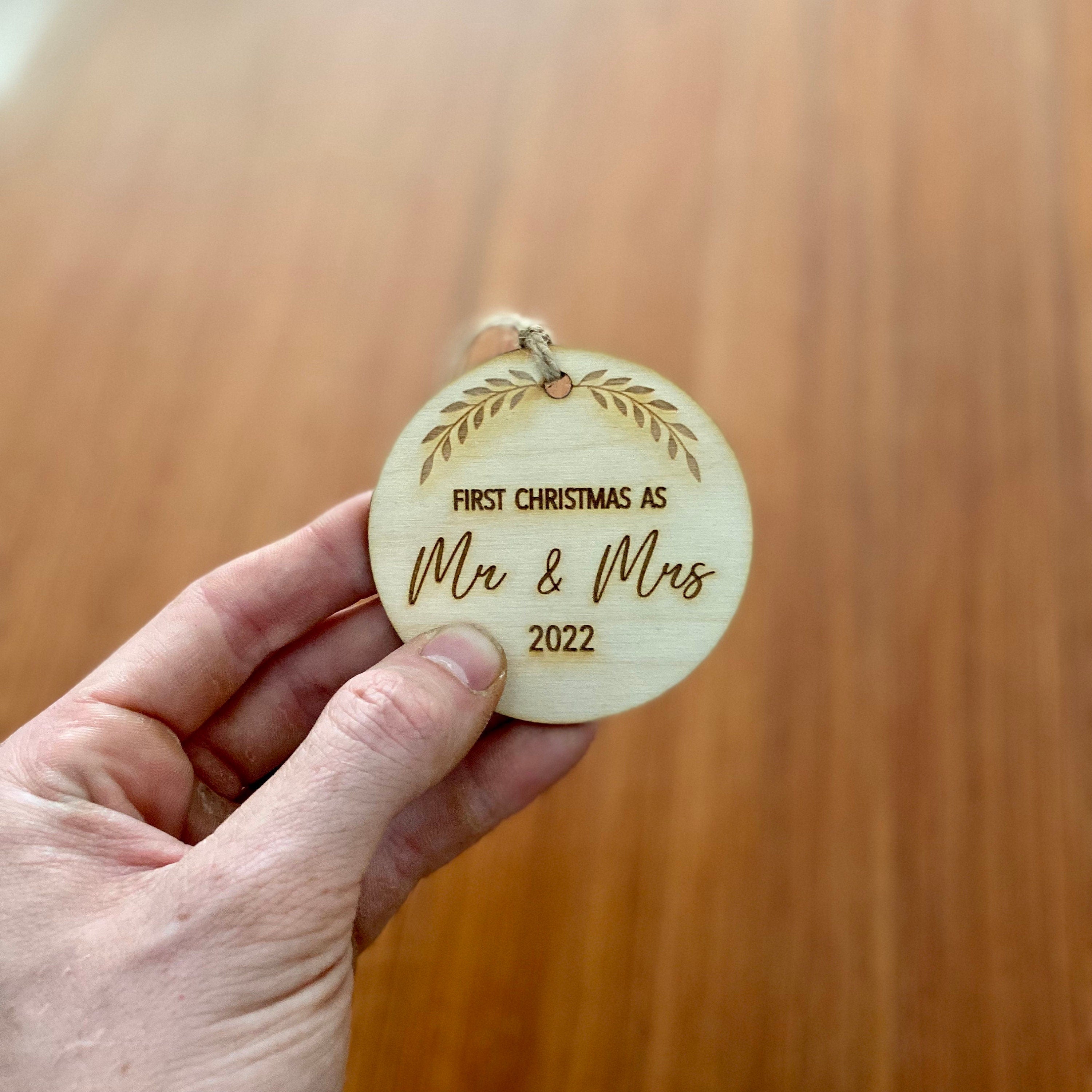 Rustic laser engraved wood slice ornament for first Christmas married, featuring a customizable year.