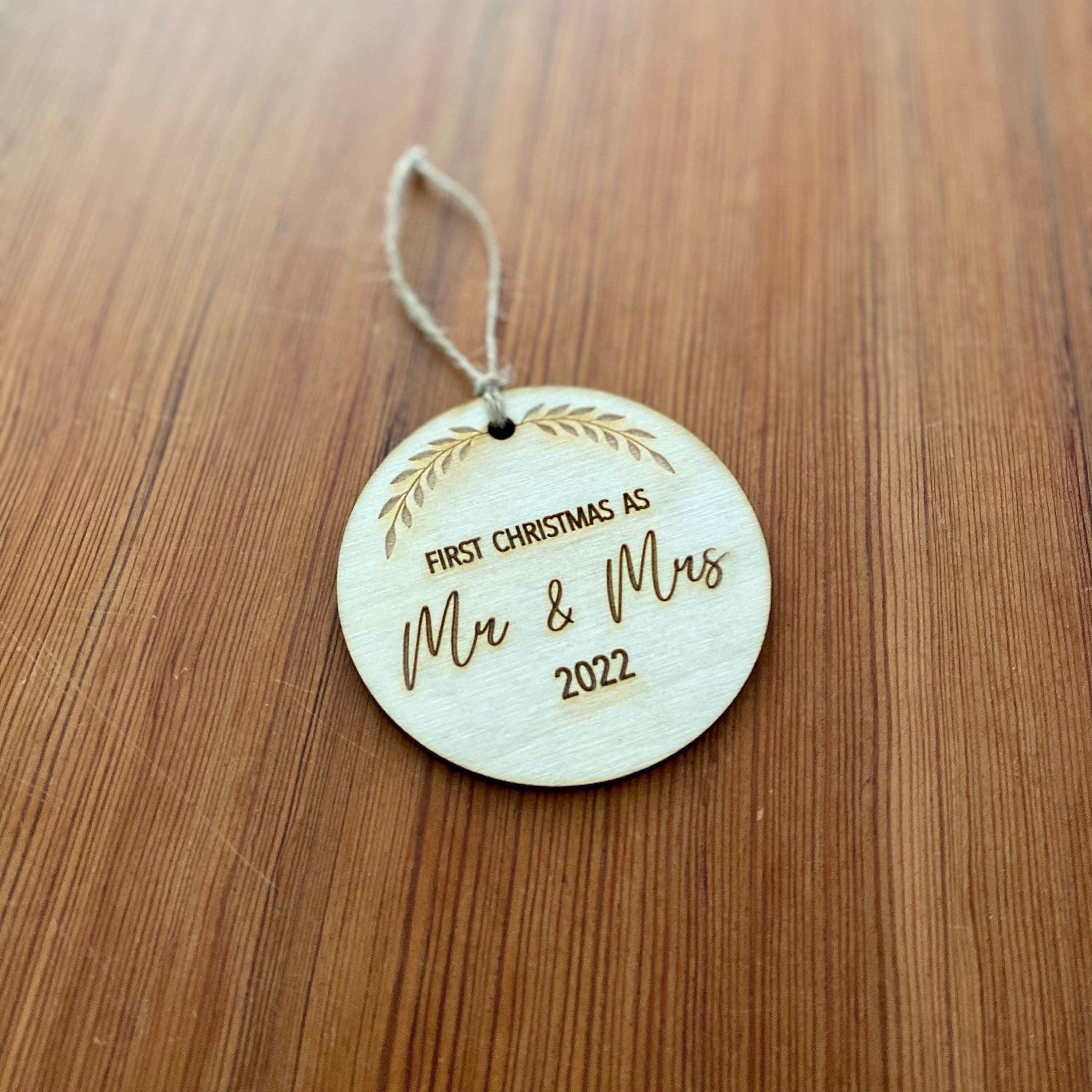 Rustic laser engraved wood slice ornament for first Christmas married, featuring a customizable year.