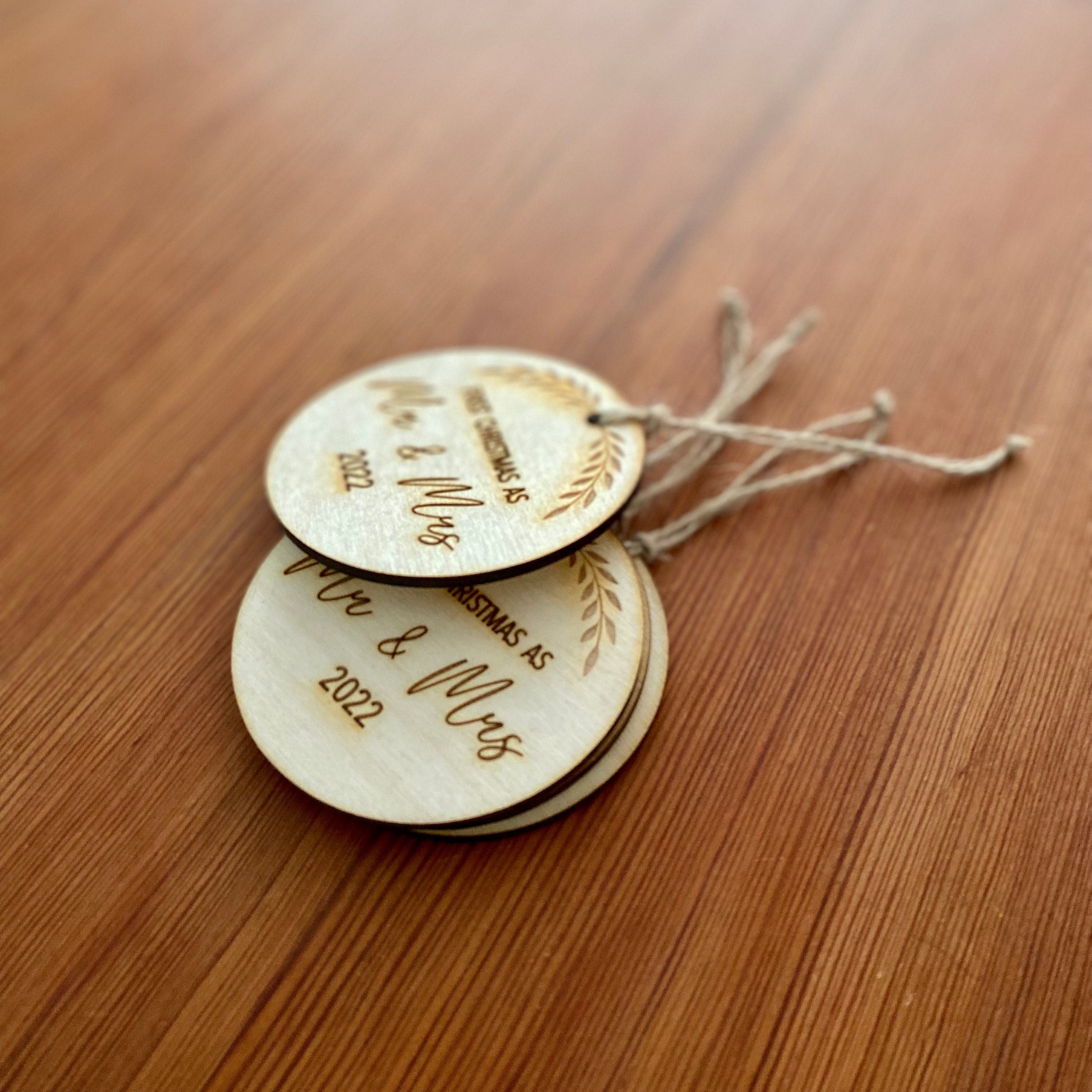 Rustic laser engraved wood slice ornament for first Christmas married, featuring a customizable year.