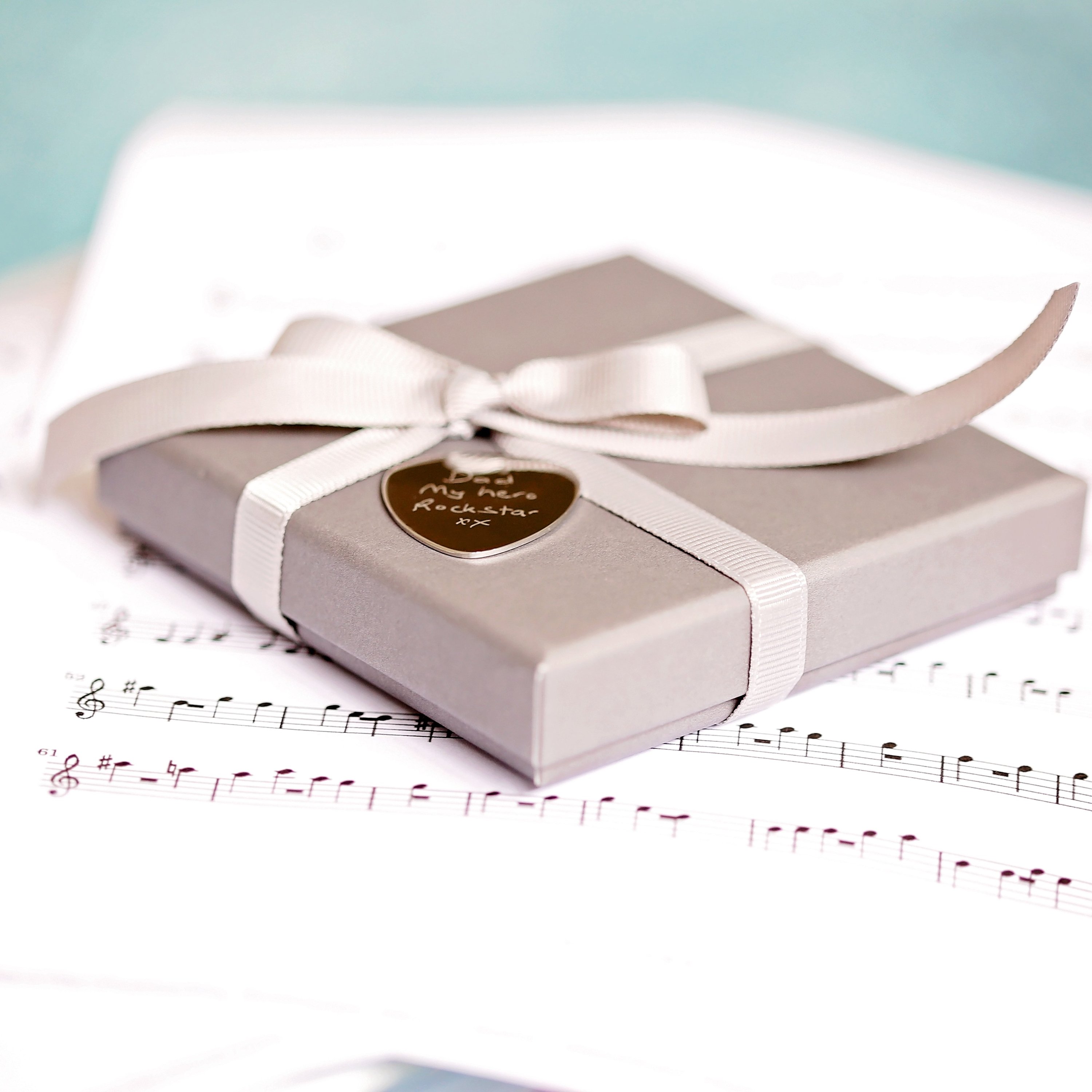 Personalised Handwriting Engraving Guitar Pick in a gift box with satin ribbon and blue zig-zag shred.