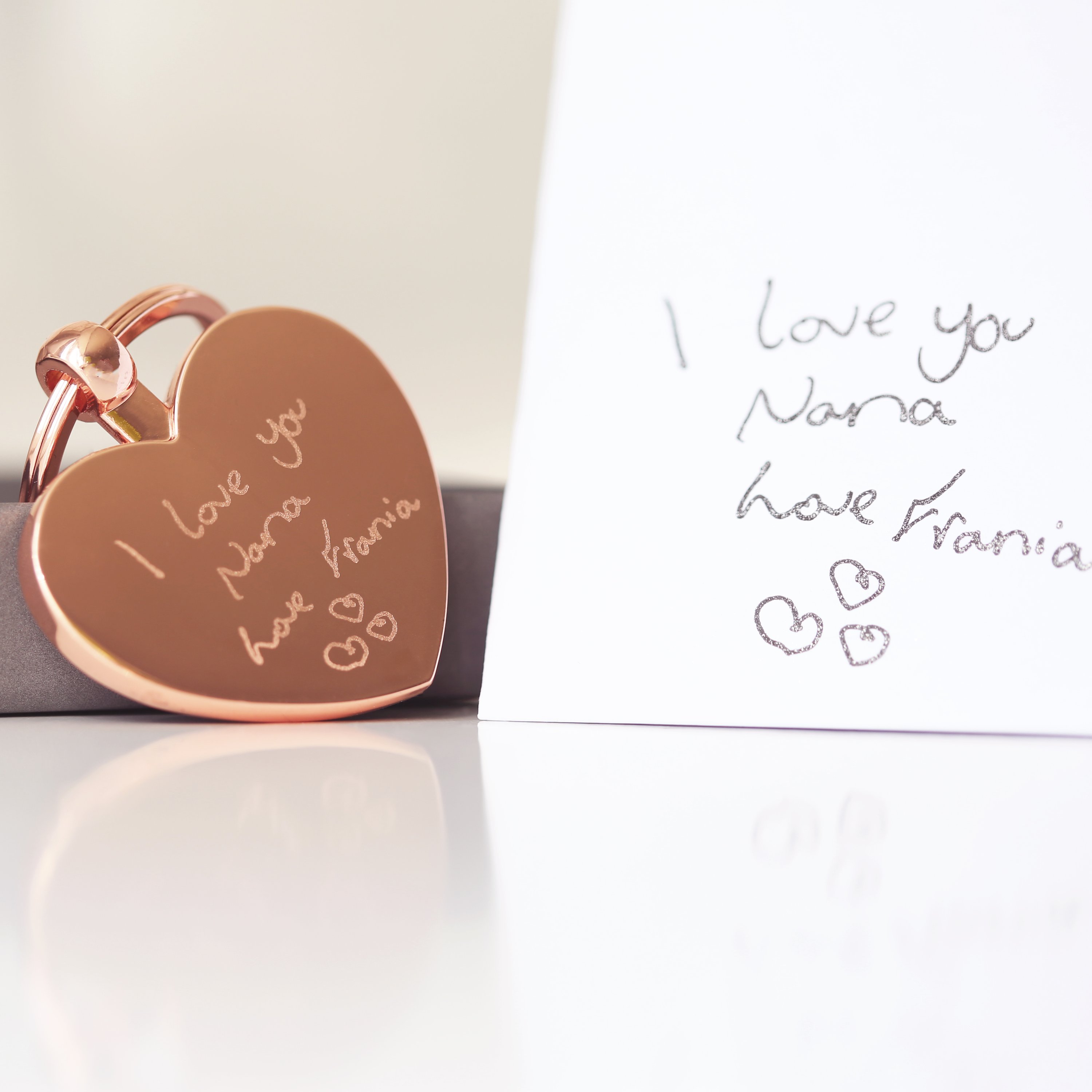 Hearts Forever keychain featuring personalized handwriting engraving, presented in a stylish gift box with blue zig-zag shred.