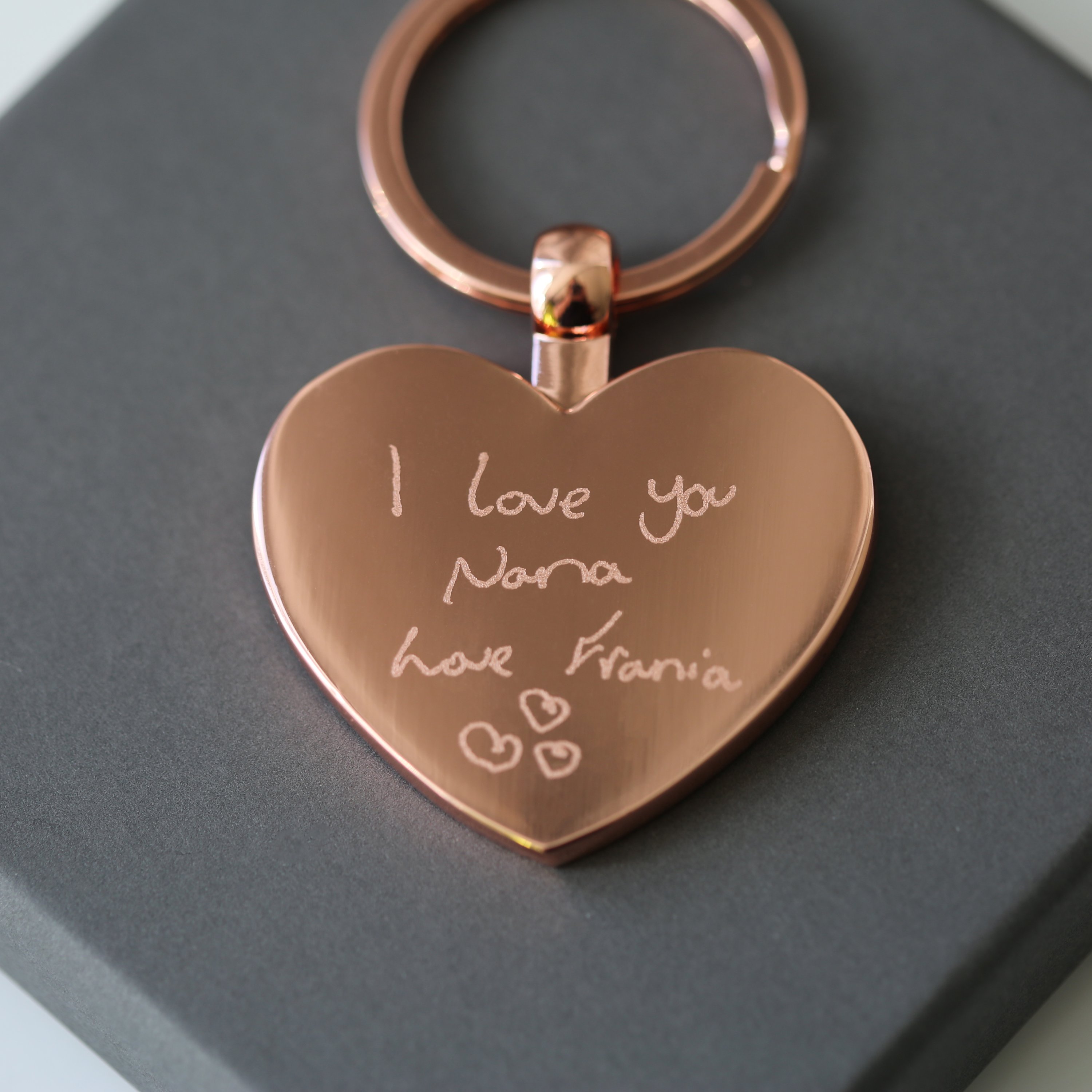 Hearts Forever keychain featuring personalized handwriting engraving, presented in a stylish gift box with blue zig-zag shred.