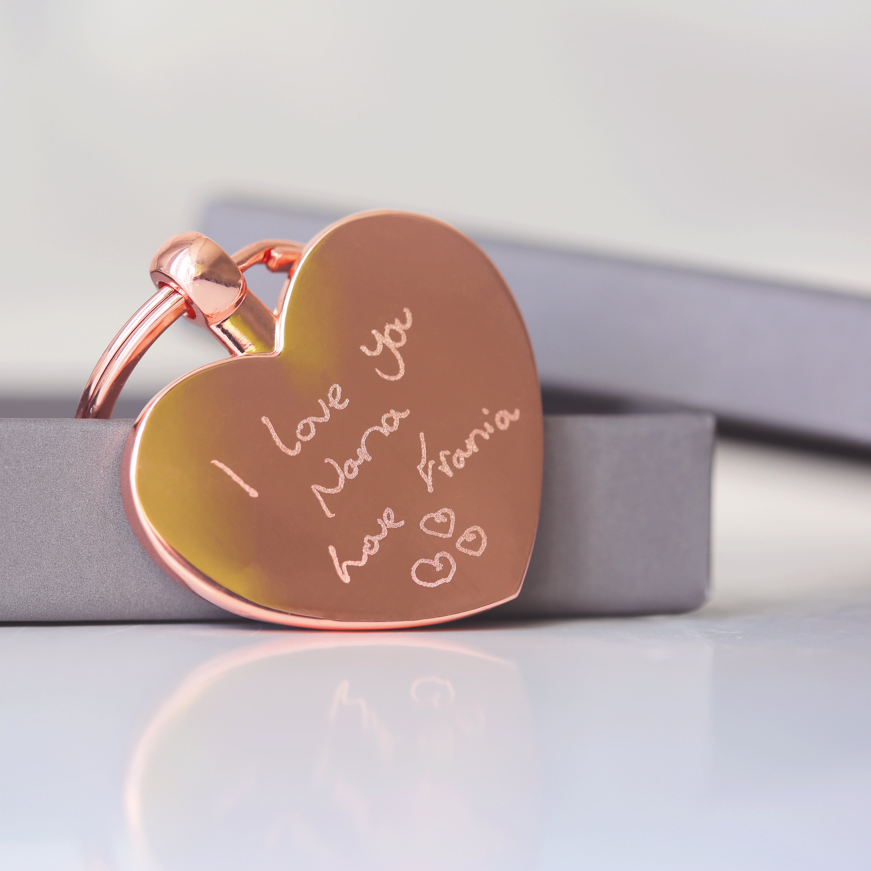 Hearts Forever keychain featuring personalized handwriting engraving, presented in a stylish gift box with blue zig-zag shred.