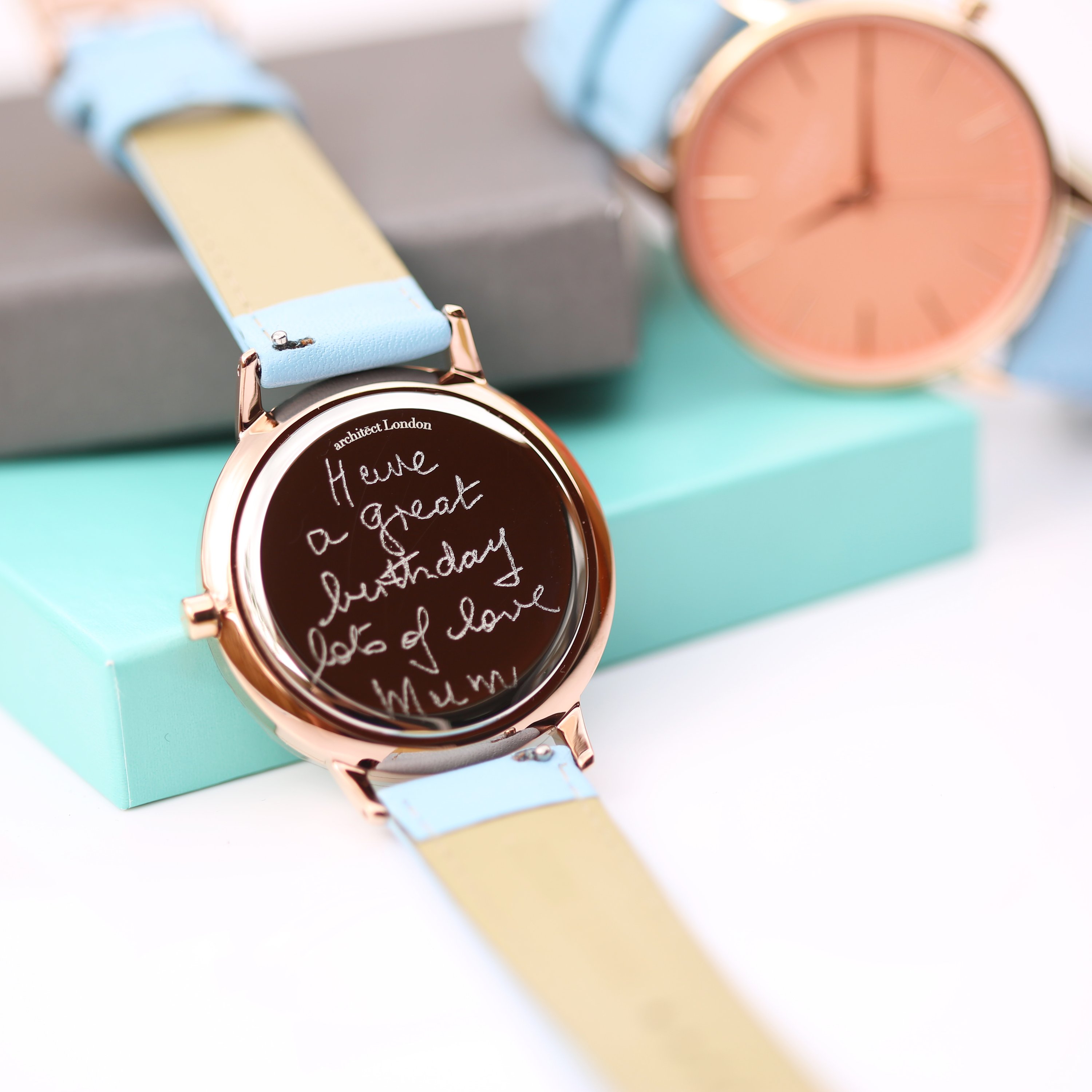 Ladies Architēct Coral watch featuring handwriting engraving and a light blue genuine leather strap, showcasing a stylish apricot coral dial.