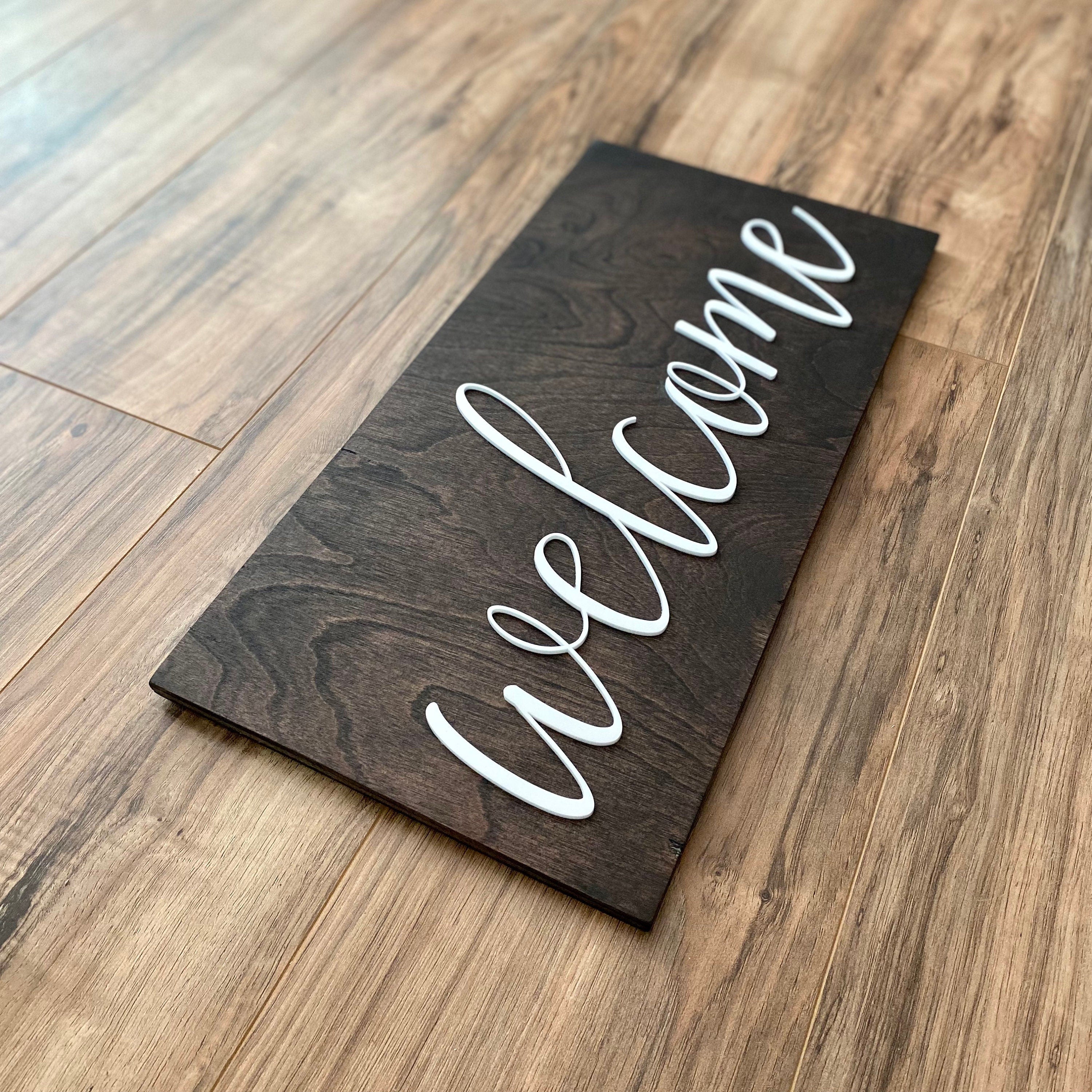 Laser Cut Wooden Welcome Sign made of birch plywood with white and black acrylic lettering, showcasing a stylish design for home decor.