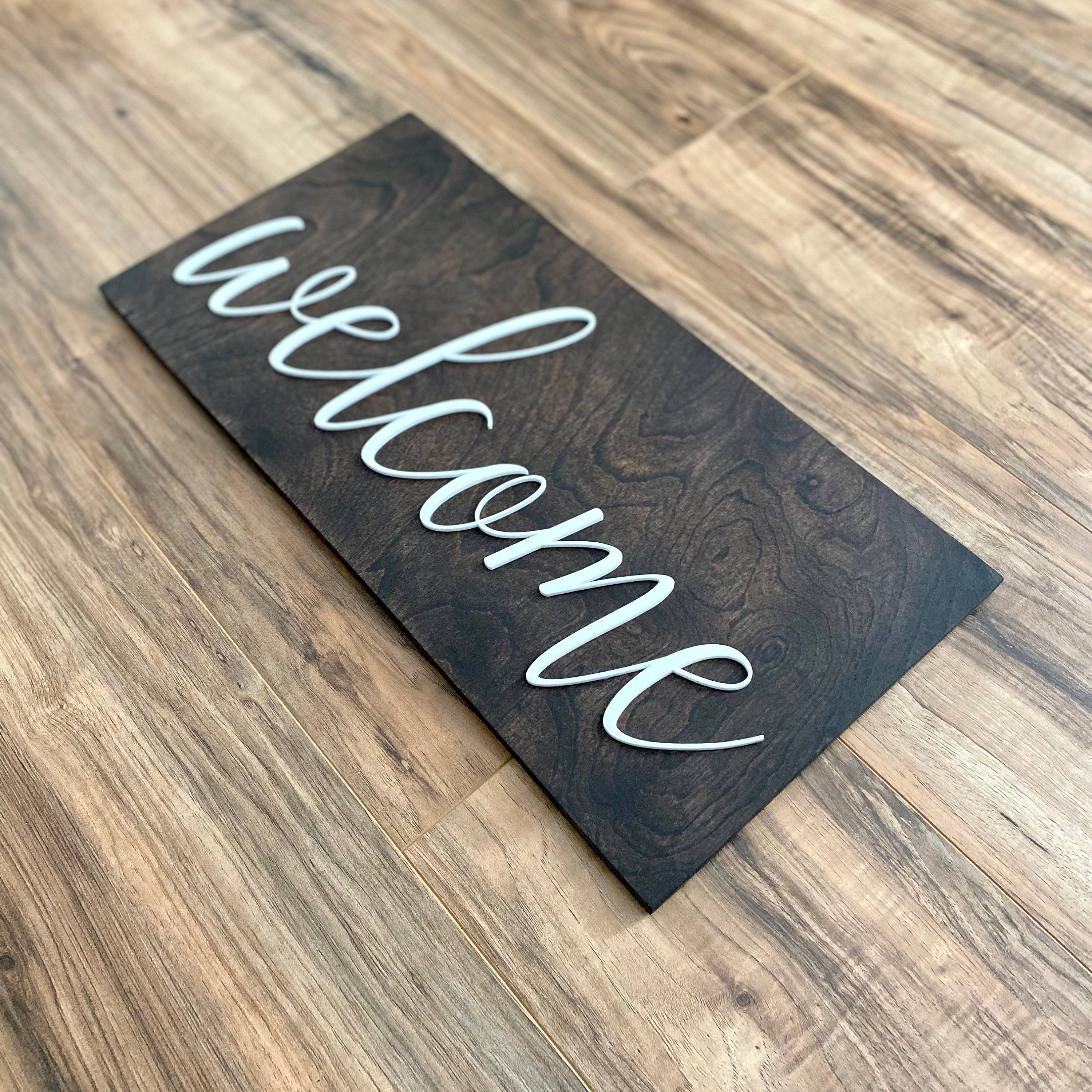 Laser Cut Wooden Welcome Sign made of birch plywood with white and black acrylic lettering, showcasing a stylish design for home decor.