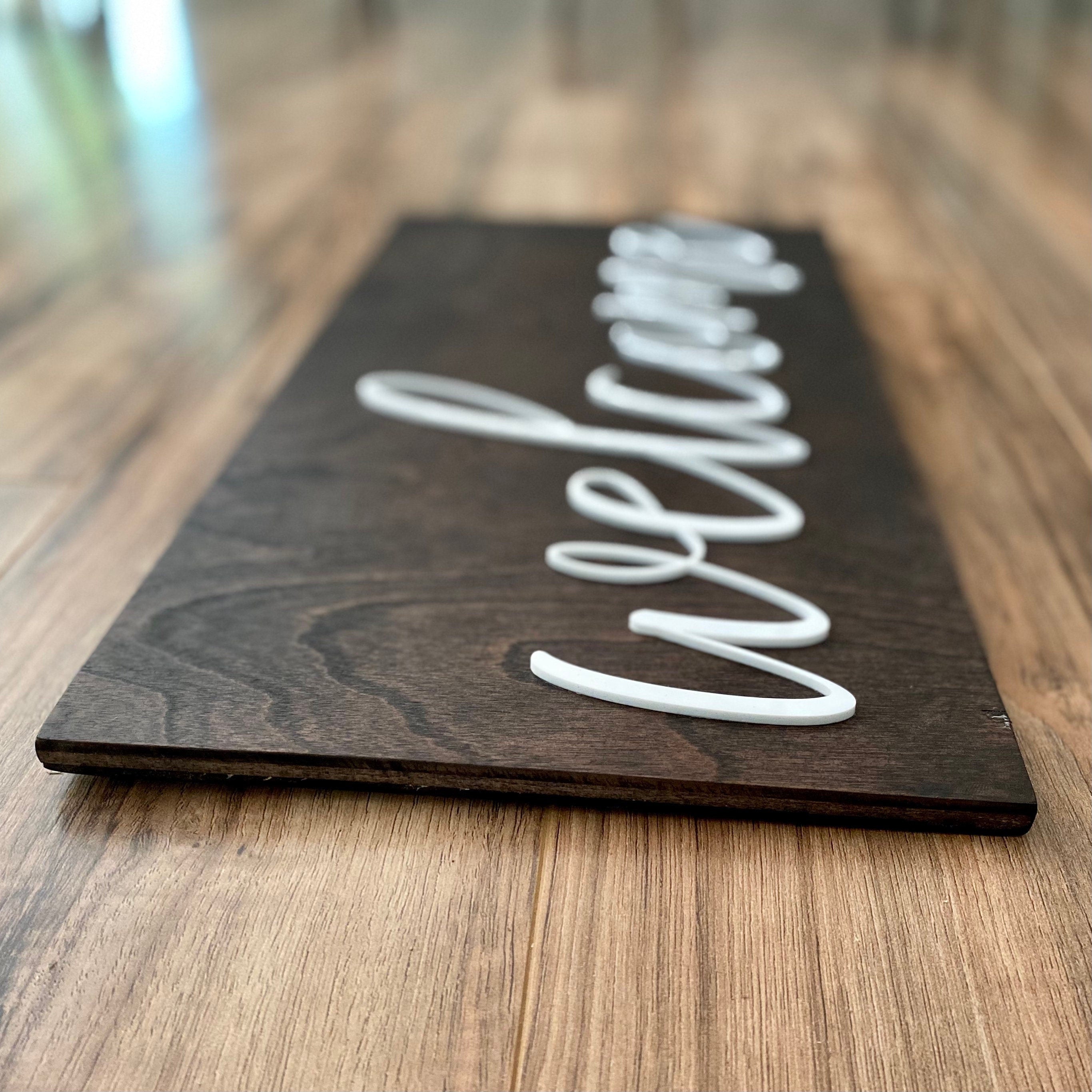 Laser Cut Wooden Welcome Sign made of birch plywood with white and black acrylic lettering, showcasing a stylish design for home decor.