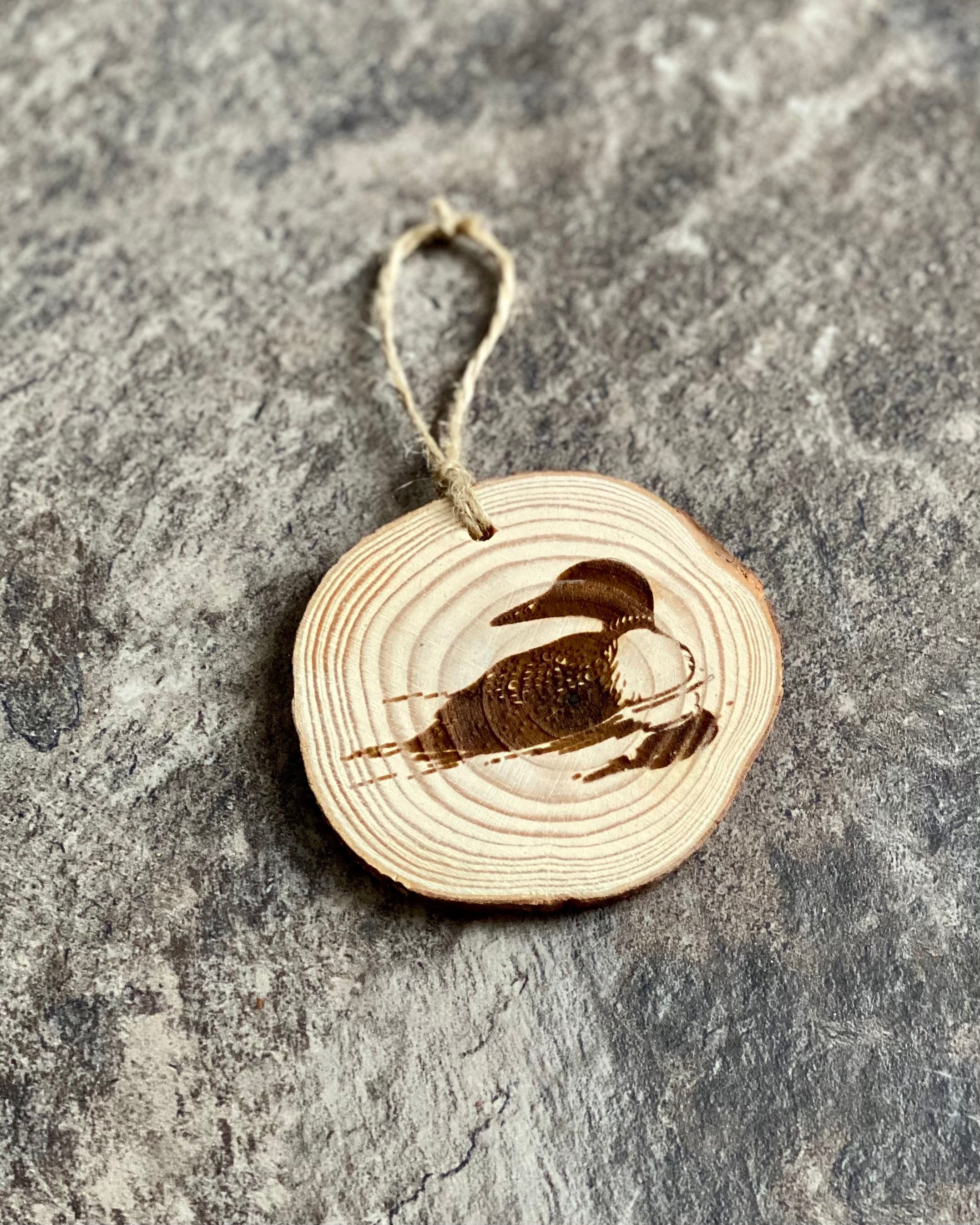 Loon Engraved Wood Christmas Ornament featuring a rustic pine wood slice with a detailed loon illustration.