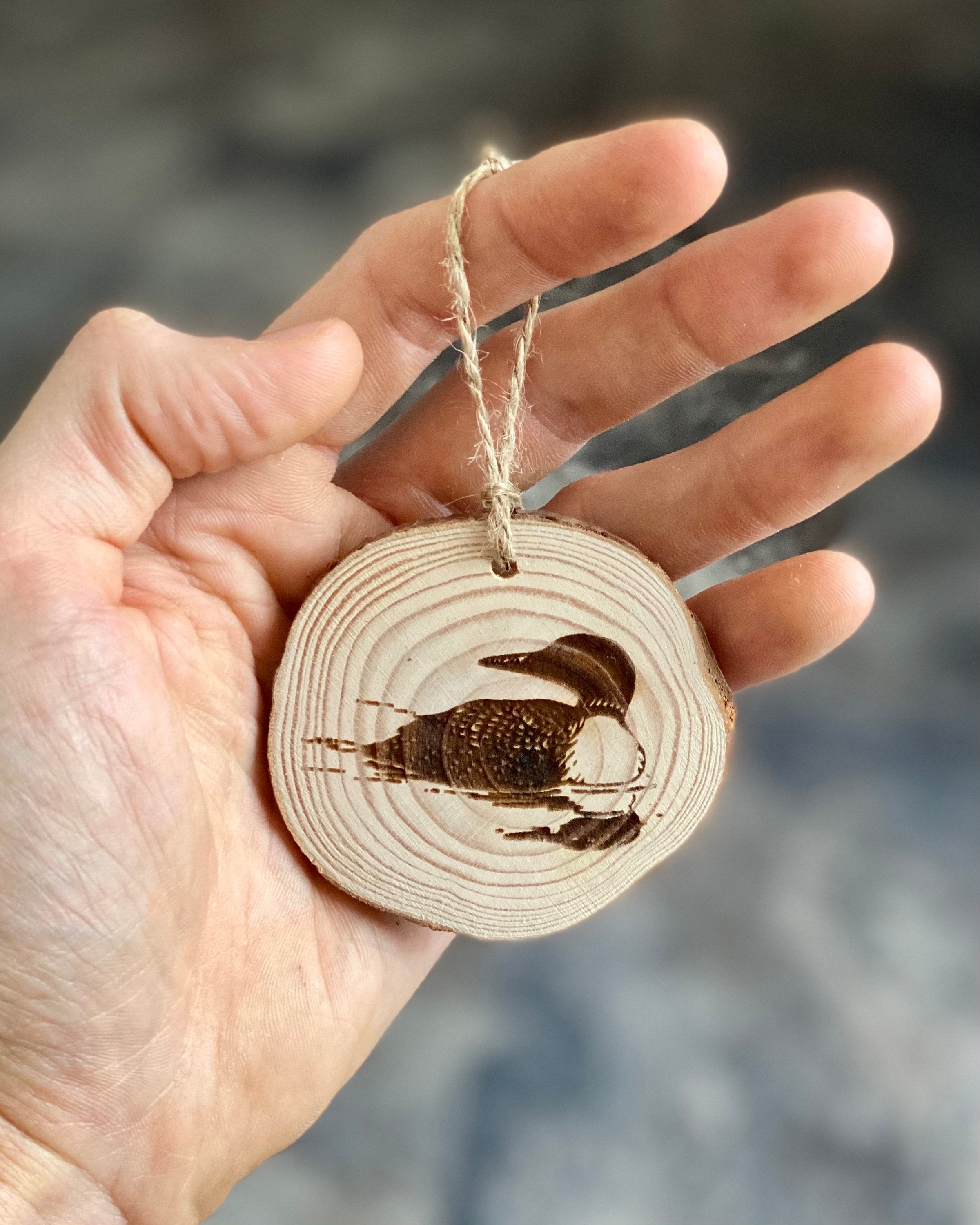 Loon Engraved Wood Christmas Ornament featuring a rustic pine wood slice with a detailed loon illustration.