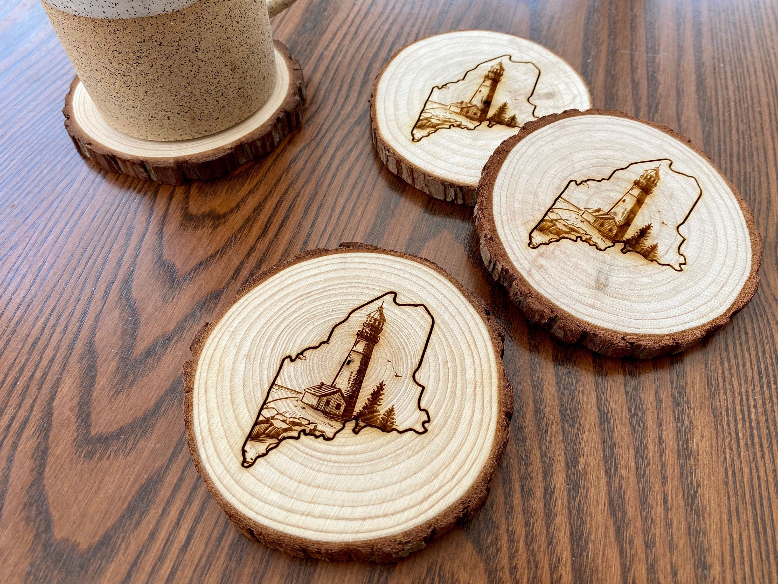 Maine Lighthouse Engraved Wood Coaster Set featuring state outline and coastal scene.