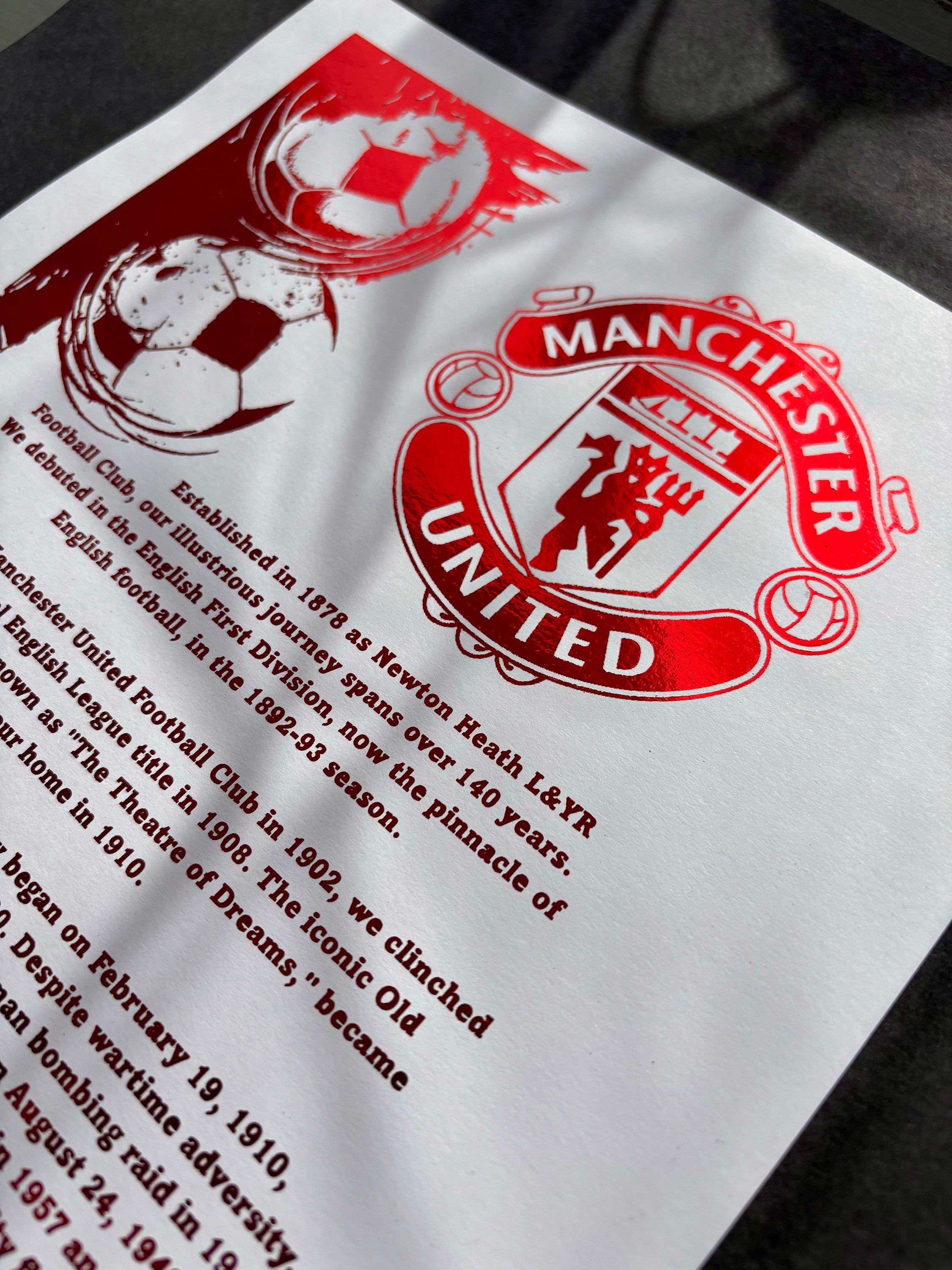 A4 foil print featuring the Manchester United FC logo in vibrant red foil, elegantly displayed.