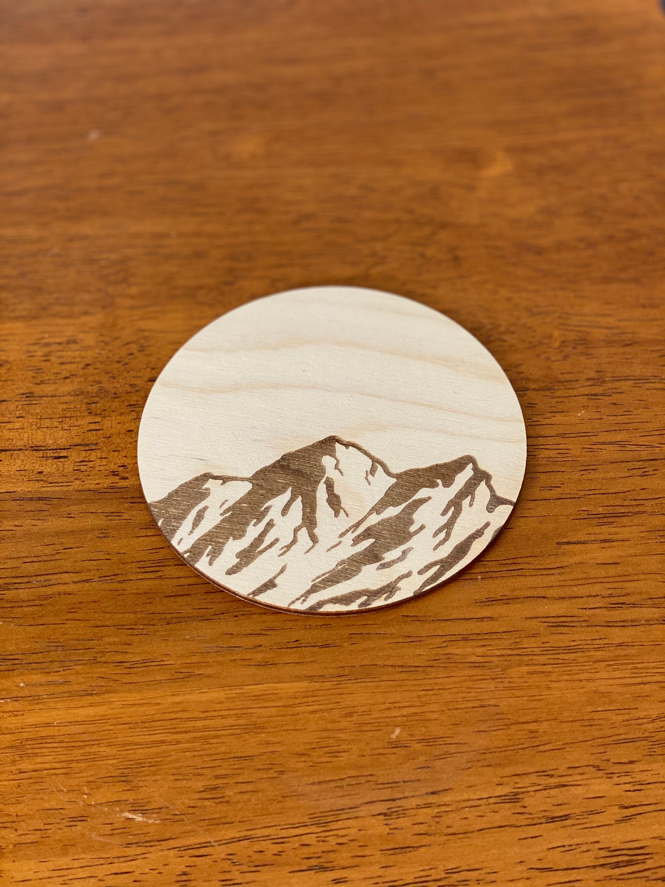 Mountain Engraved Wood Coaster Set featuring pine tree and bird designs, made from high-quality Baltic Birch.