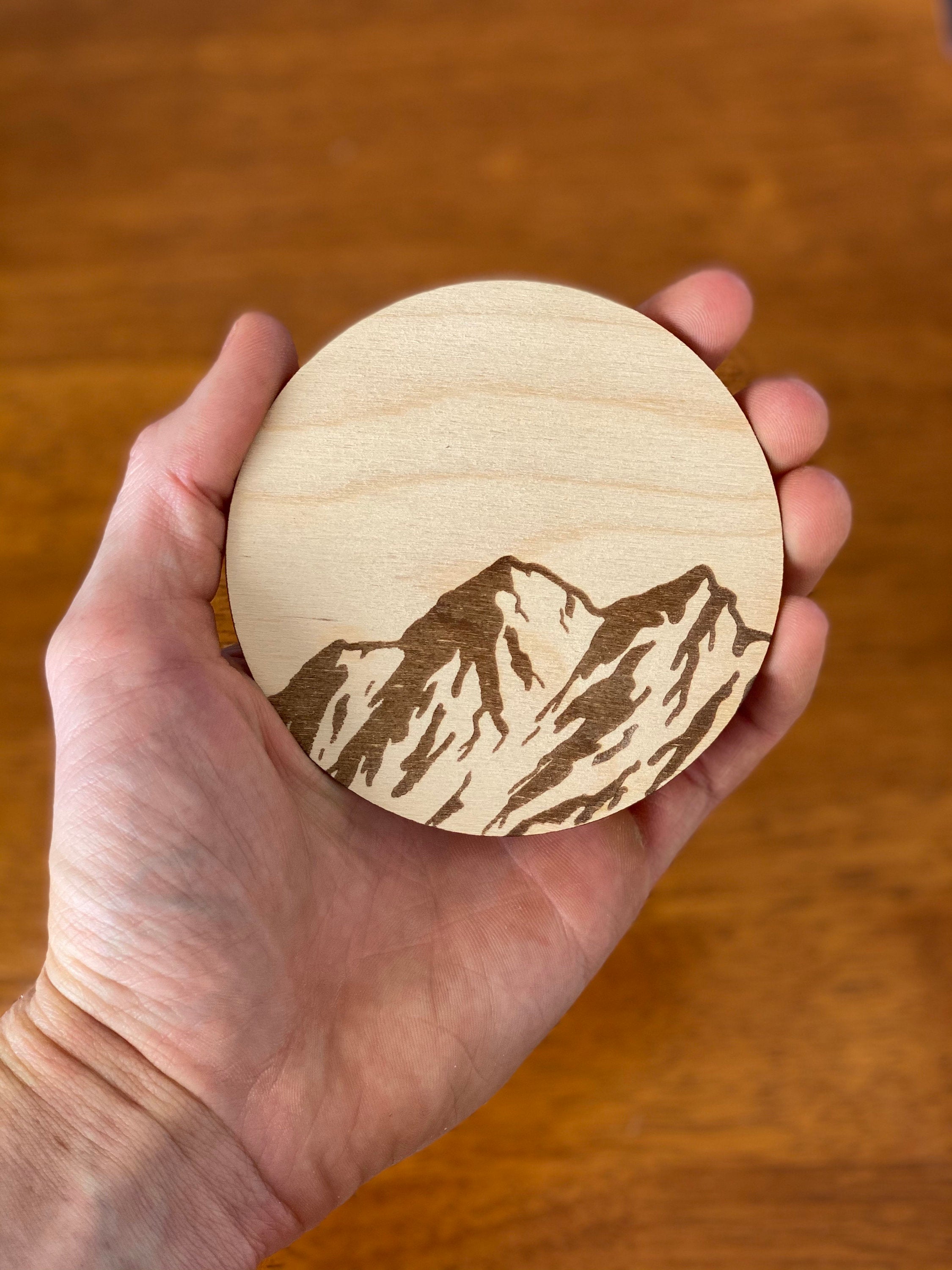 Mountain Engraved Wood Coaster Set featuring pine tree and bird designs, made from high-quality Baltic Birch.