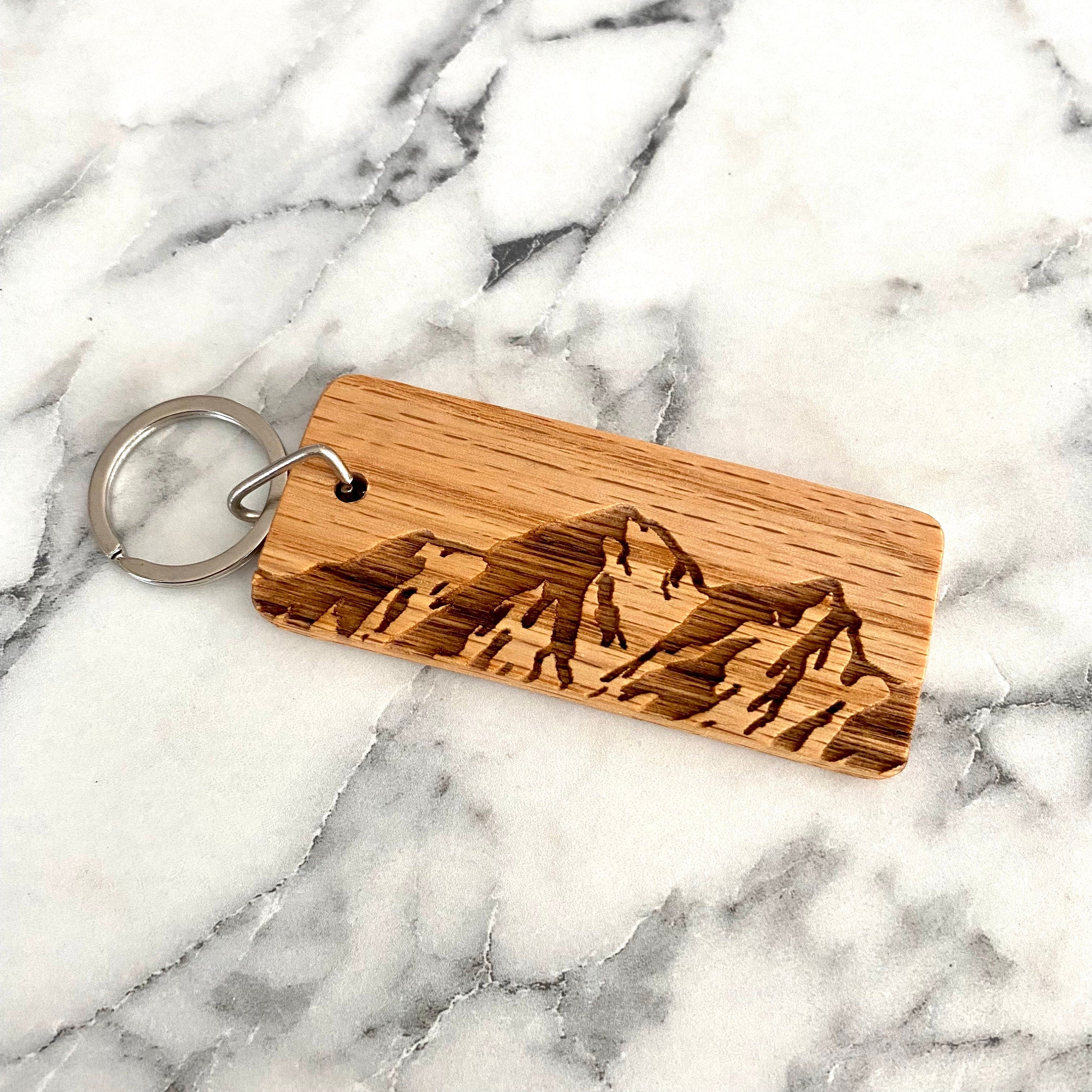 Mountain Engraved Wood Keychain made from solid oak with a laser-engraved mountain range design.