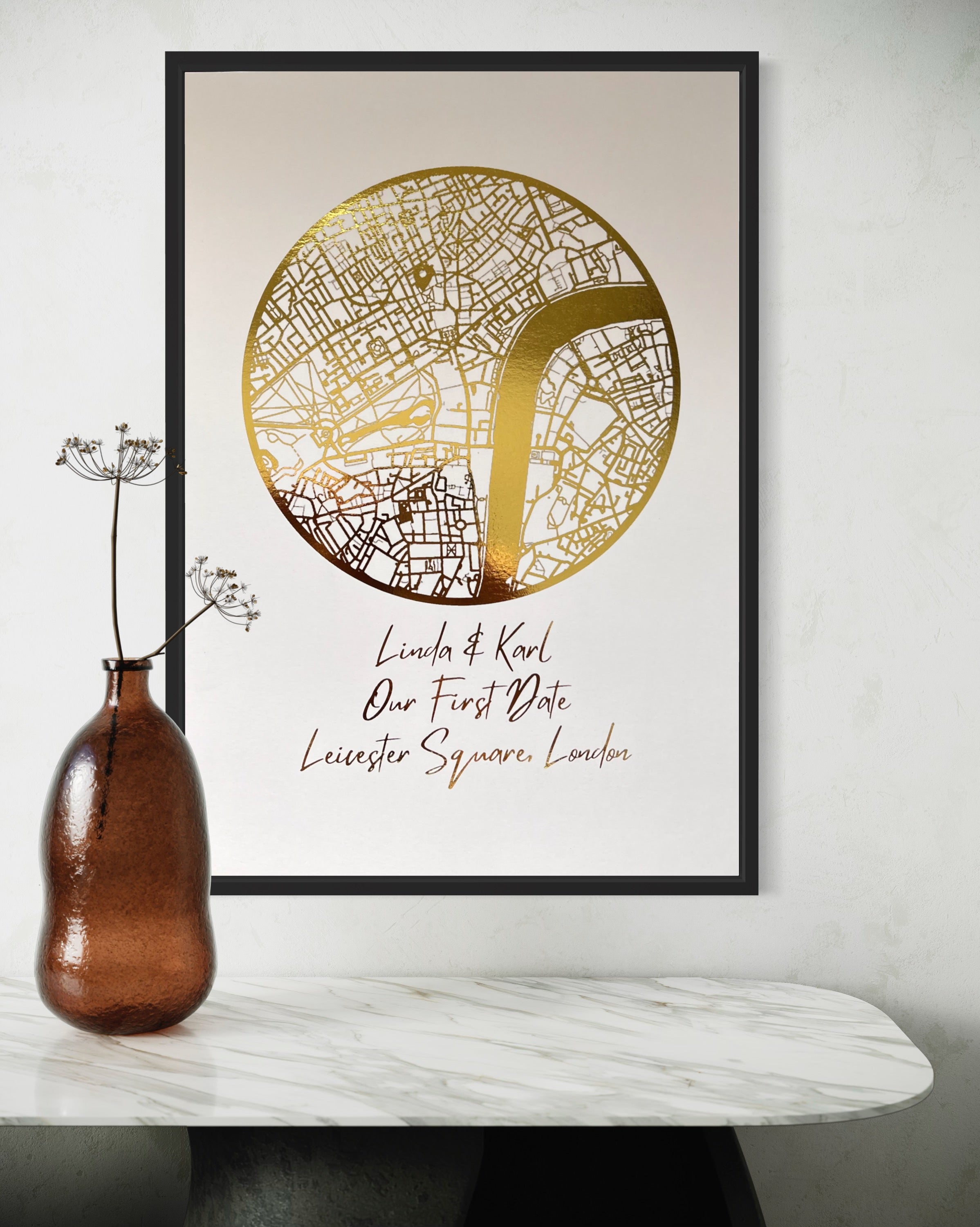 A beautifully crafted gold foil printed map in a circle shape, personalized with names and a location, symbolizing a couple's first date.