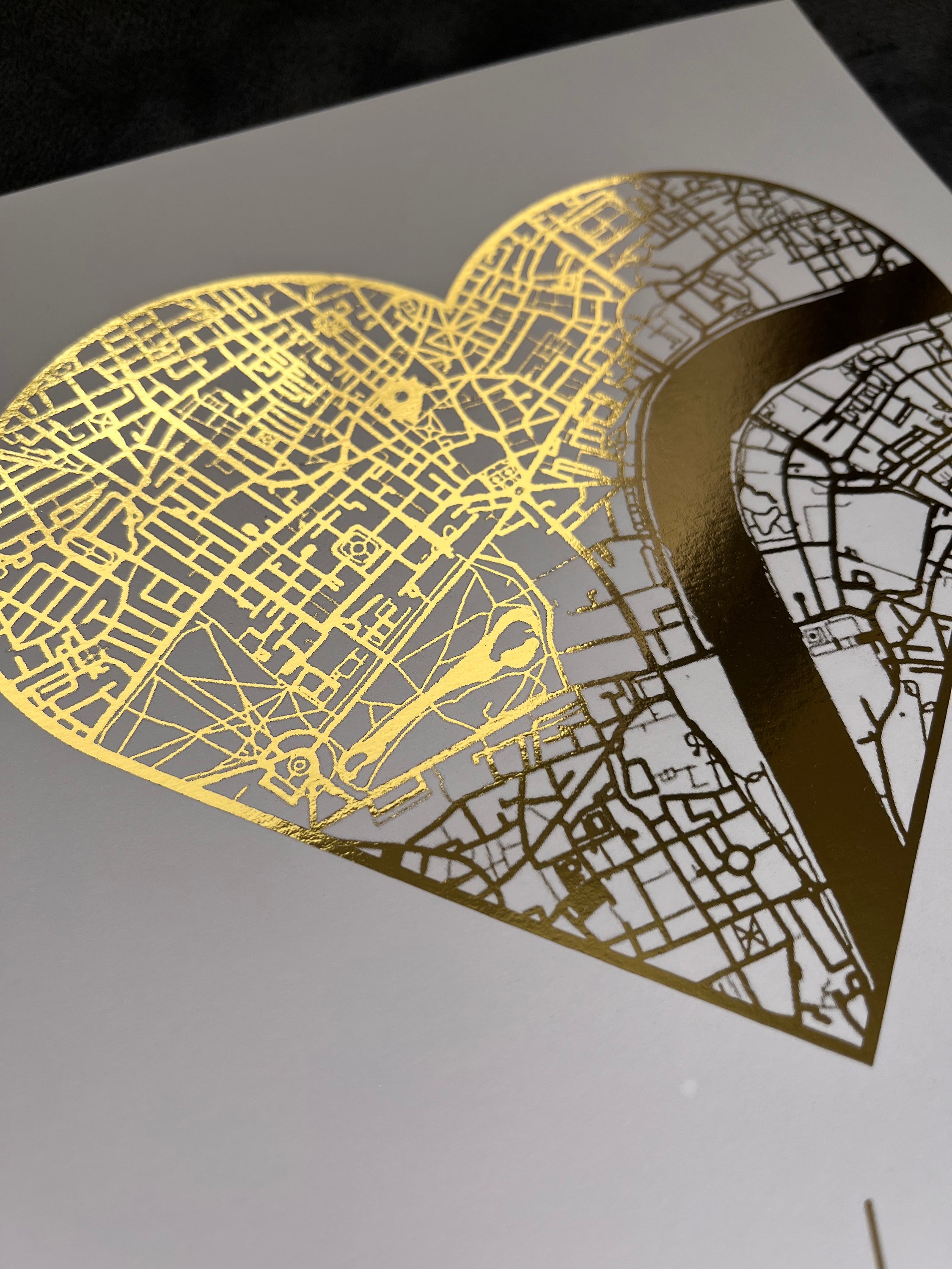 A beautifully crafted heart-shaped map featuring gold foil printing, personalized with couple's names and first date location.