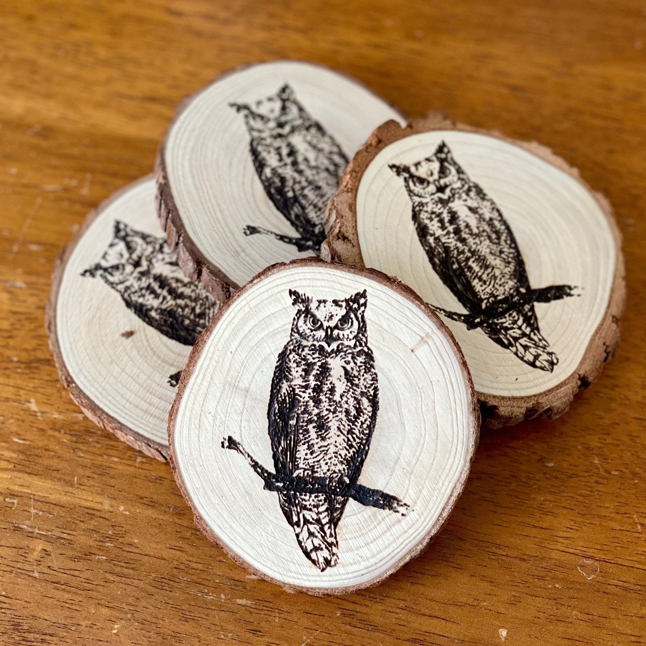 A set of four laser engraved wood coasters featuring intricate owl designs, showcasing their natural wood finish and unique craftsmanship.