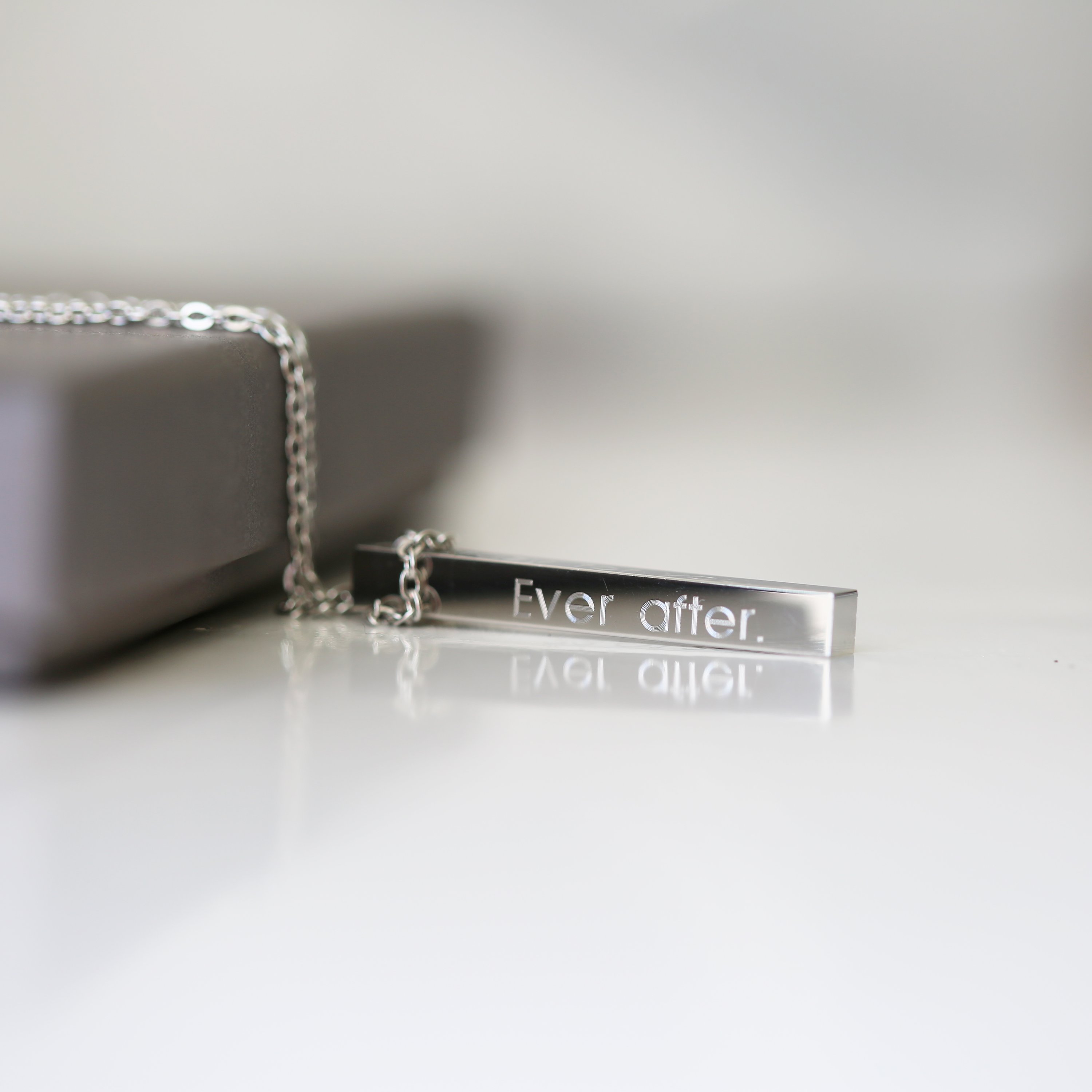 A modern personalised bar necklace available in silver, gold, and rose gold, elegantly engraved with a custom message.