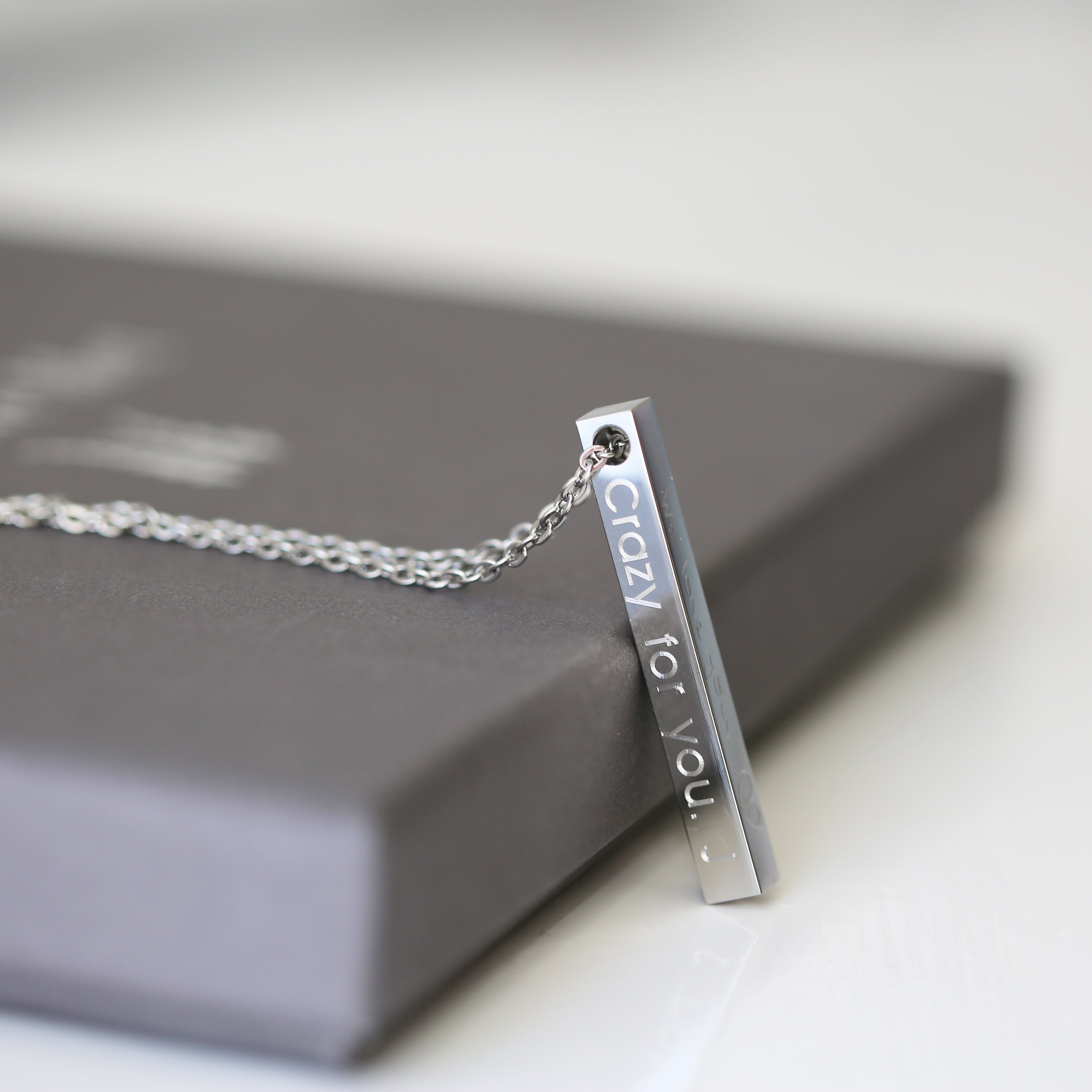 A modern personalised bar necklace available in silver, gold, and rose gold, elegantly engraved with a custom message.