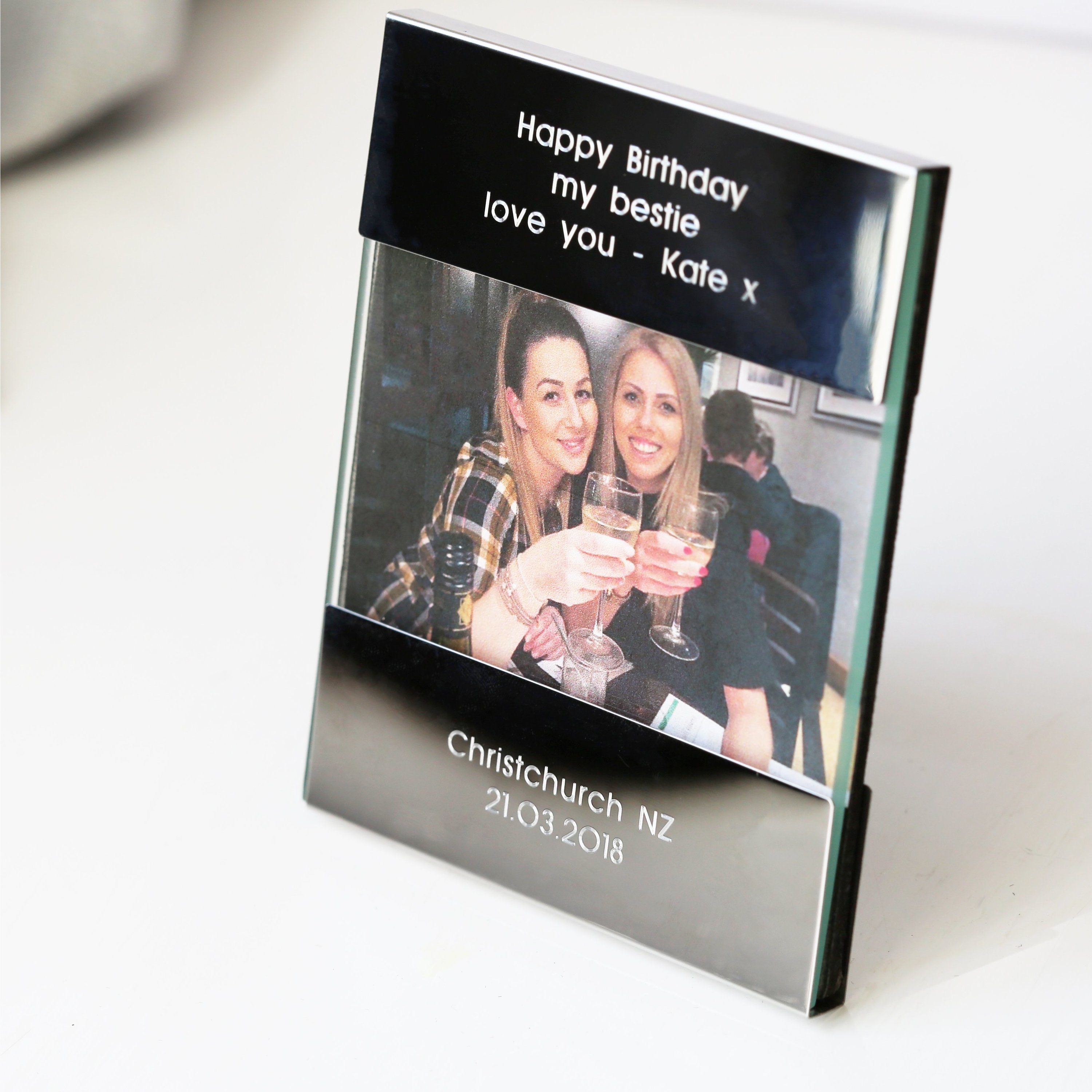 A sleek, polished stainless steel photo frame with custom engraving, displaying a cherished photo.