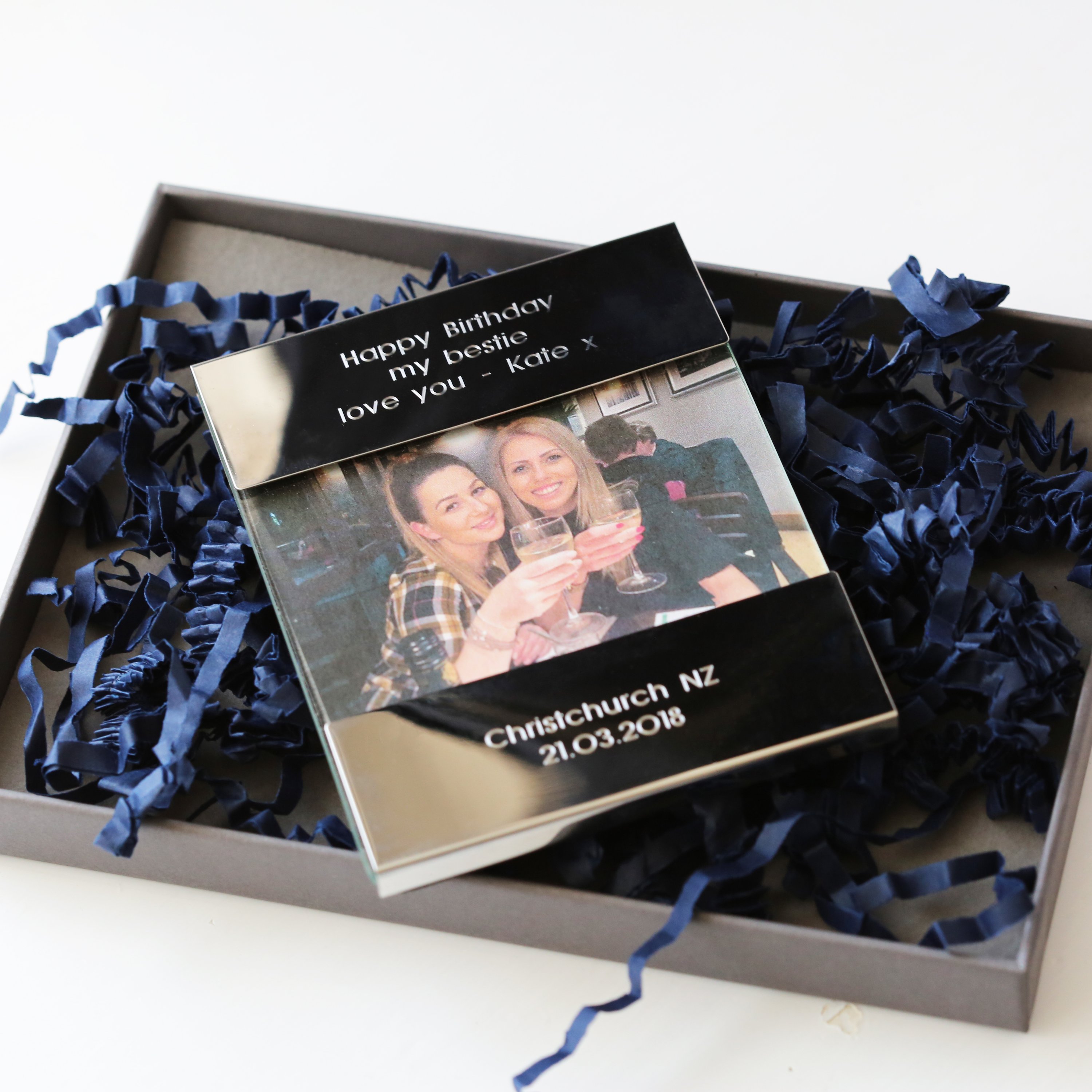 A sleek, polished stainless steel photo frame with custom engraving, displaying a cherished photo.