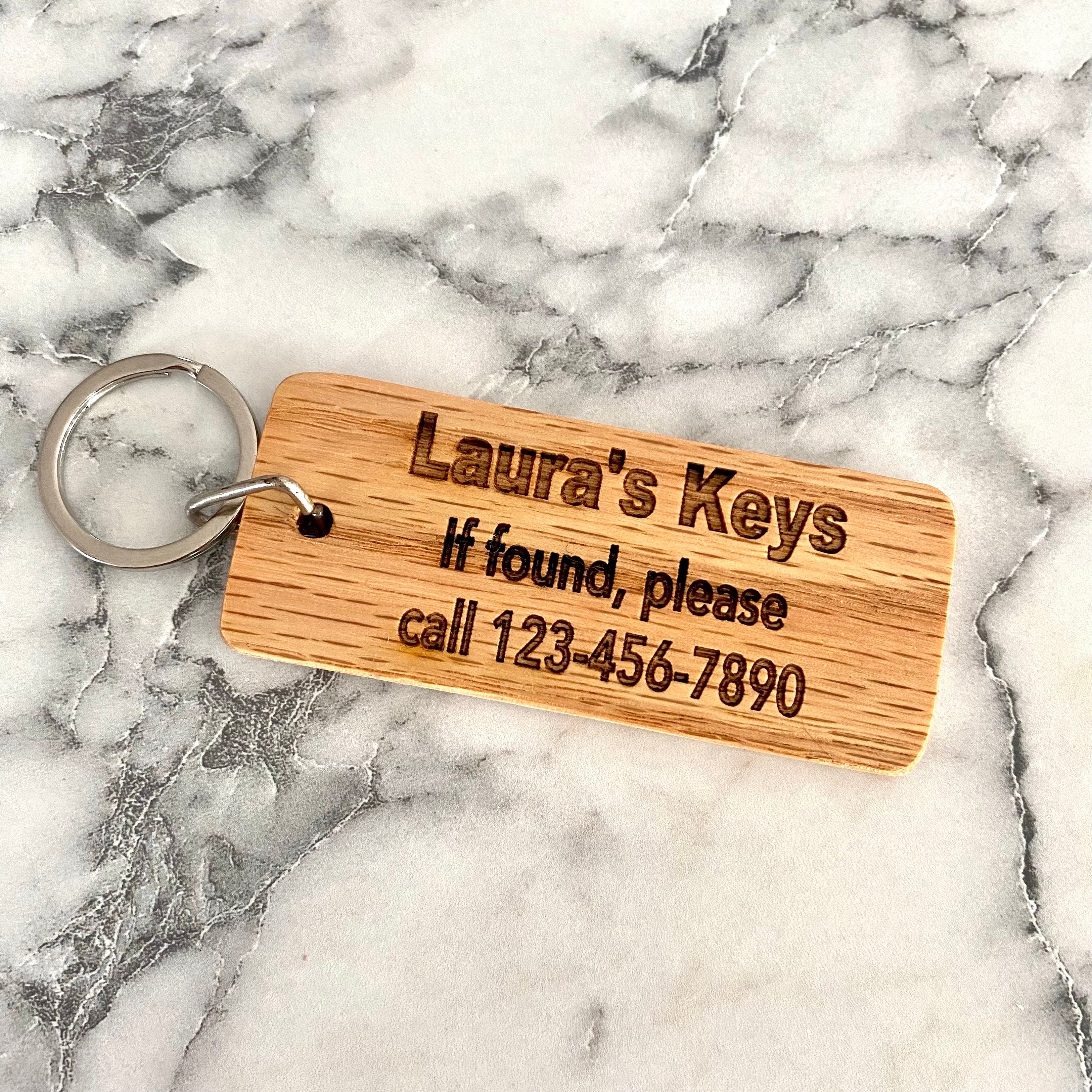 Personalized engraved wood keychain with contact information, crafted from solid oak, showcasing custom engraving and natural finish.